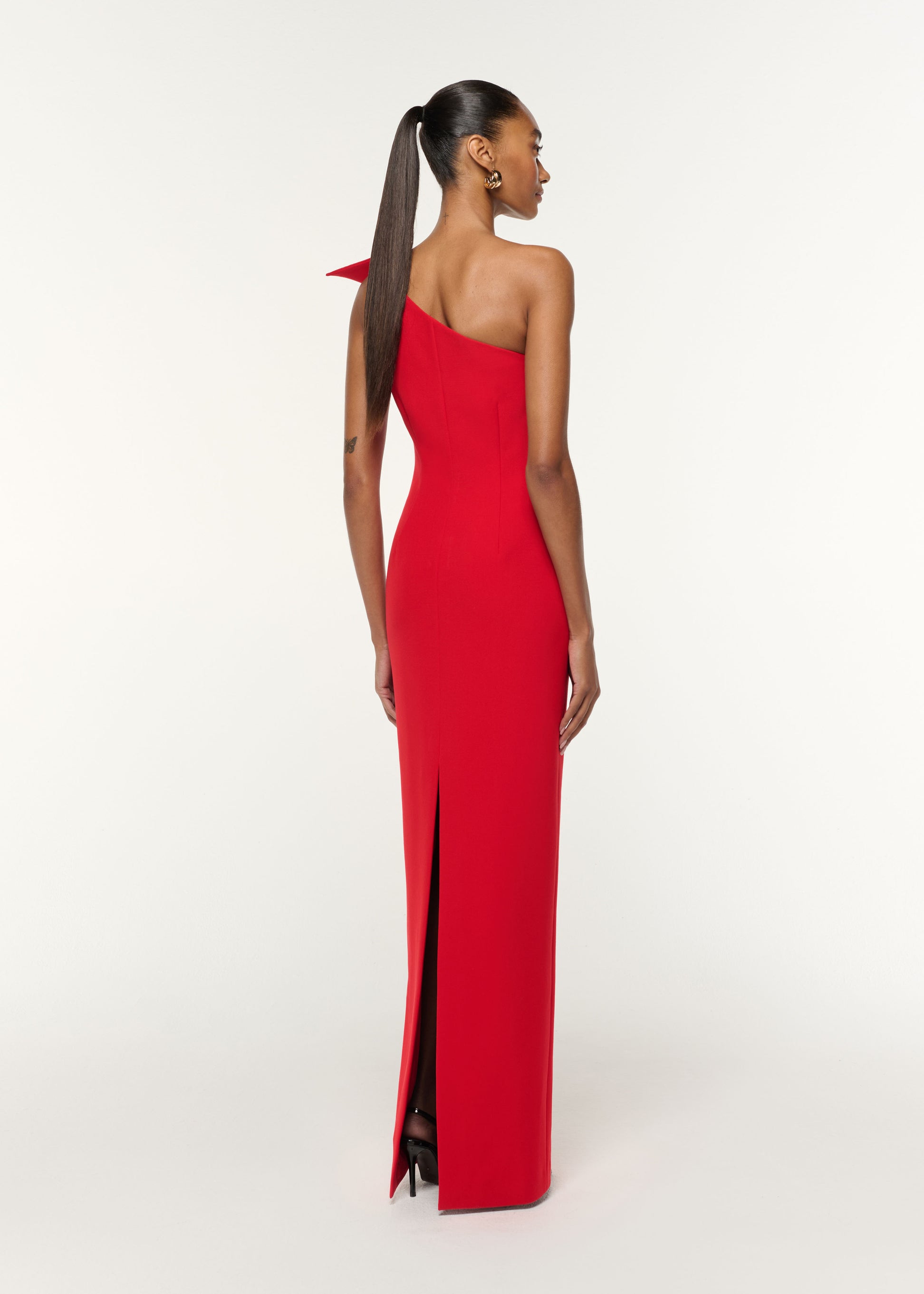 Back view of a model wearing the Structured Drape One Shoulder Crepe Gown in Red