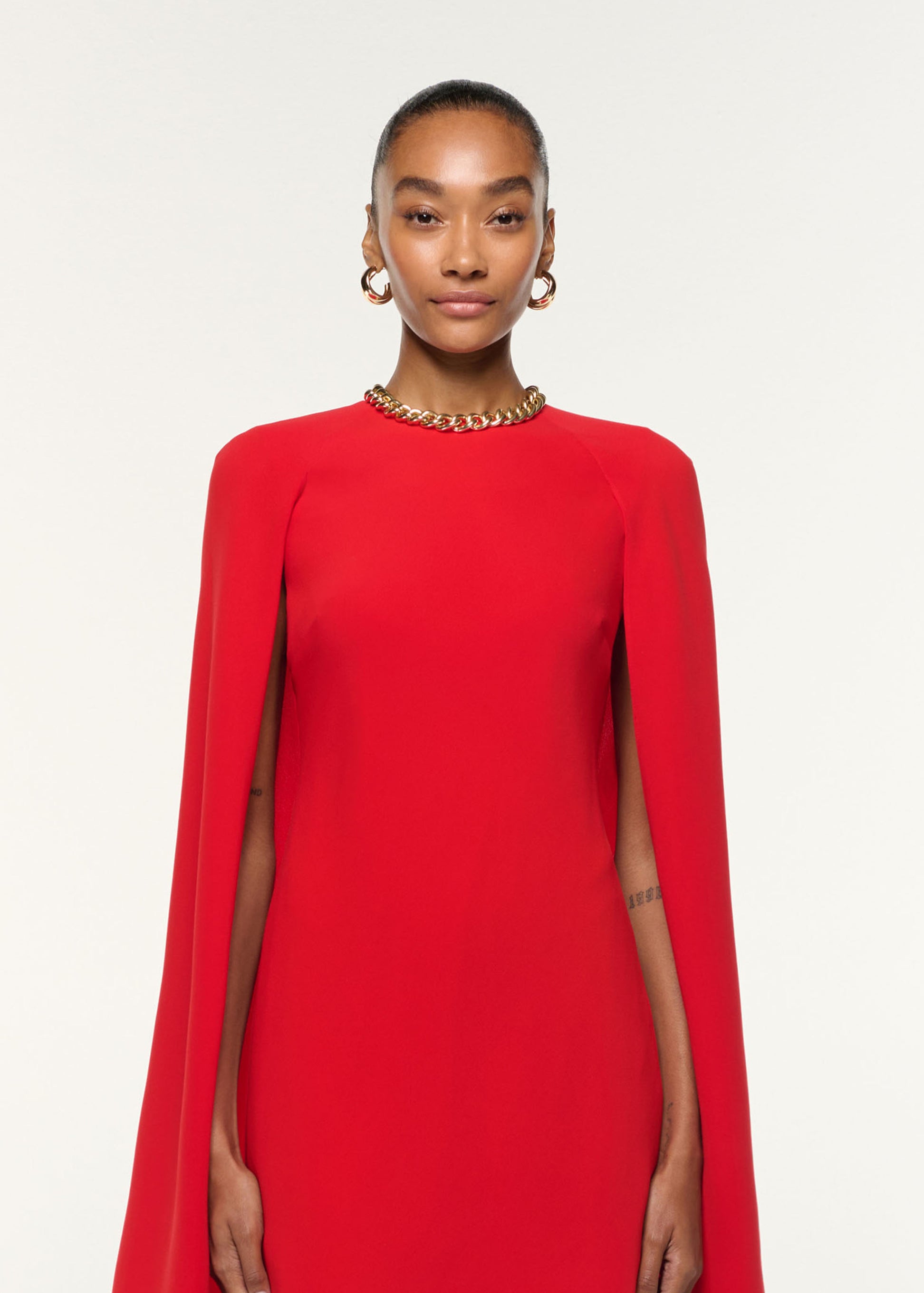 Close up of a model wearing the Light Cady Cape Dress in Red