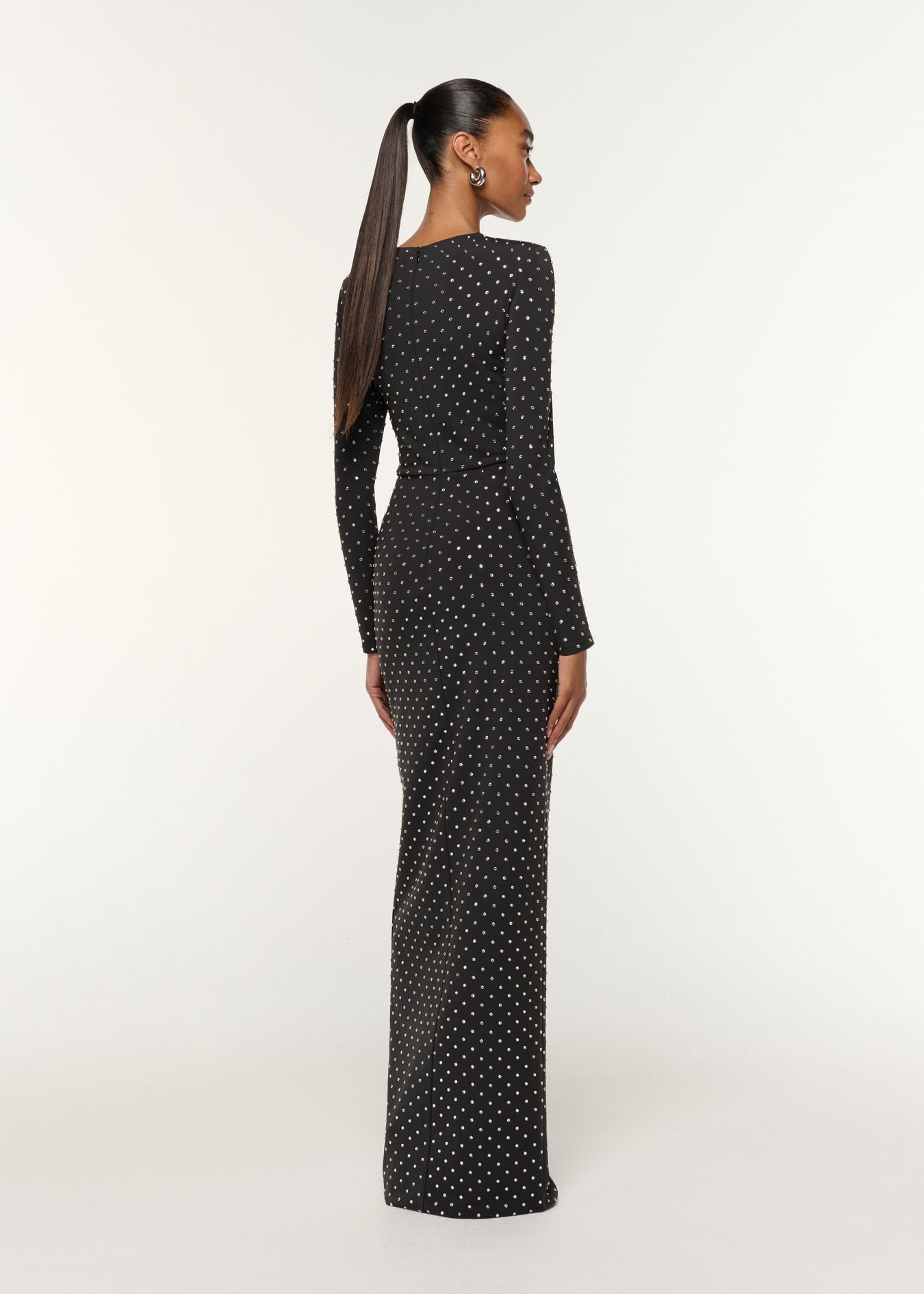 Back view of a model wearing the Jersey Diamante Drape And Metal Trim Gown in Black