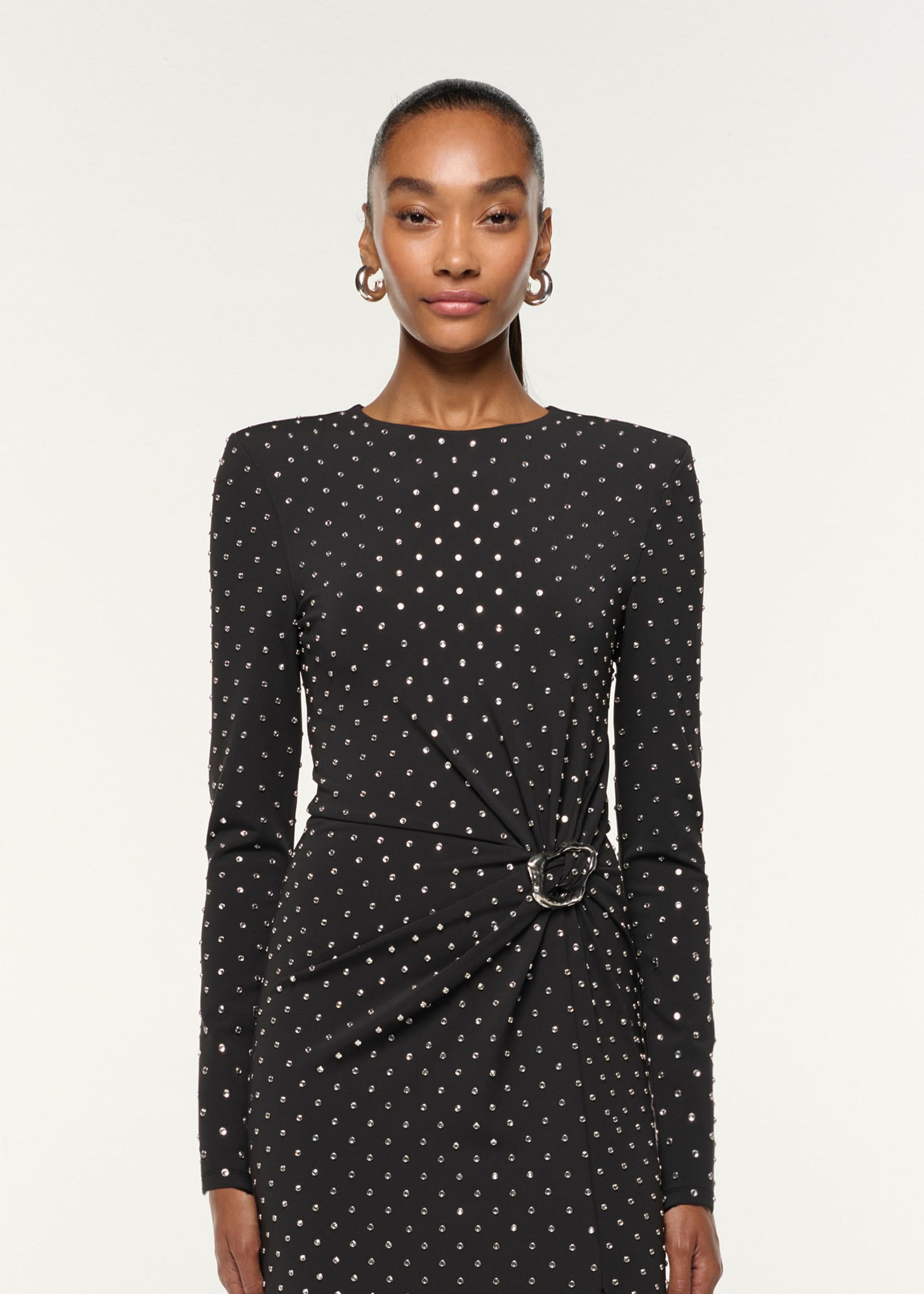 Close up of a model wearing the Jersey Diamante Drape And Metal Trim Gown in Black