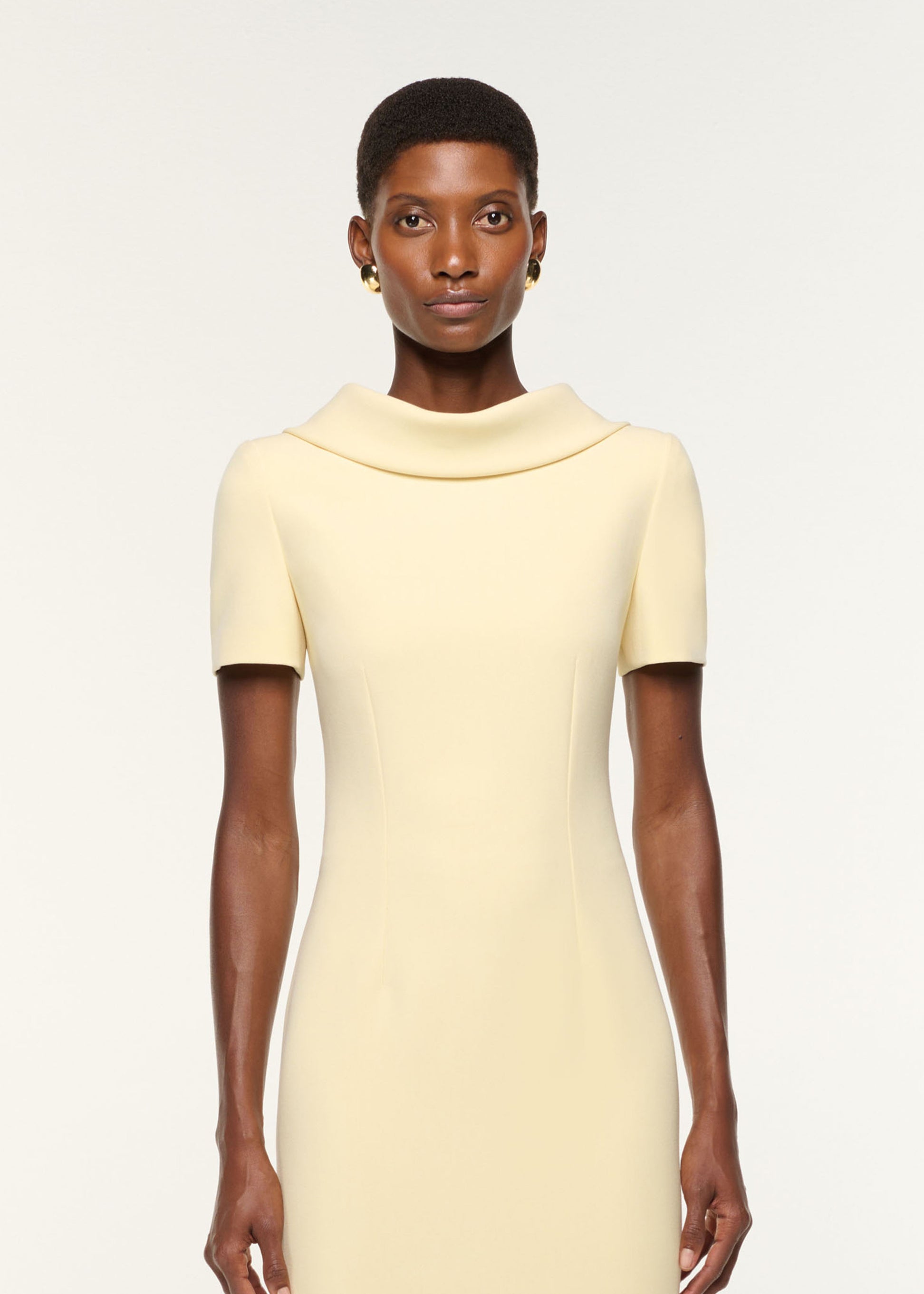 Close up of a model wearing the Collared Crepe Gown in Yellow