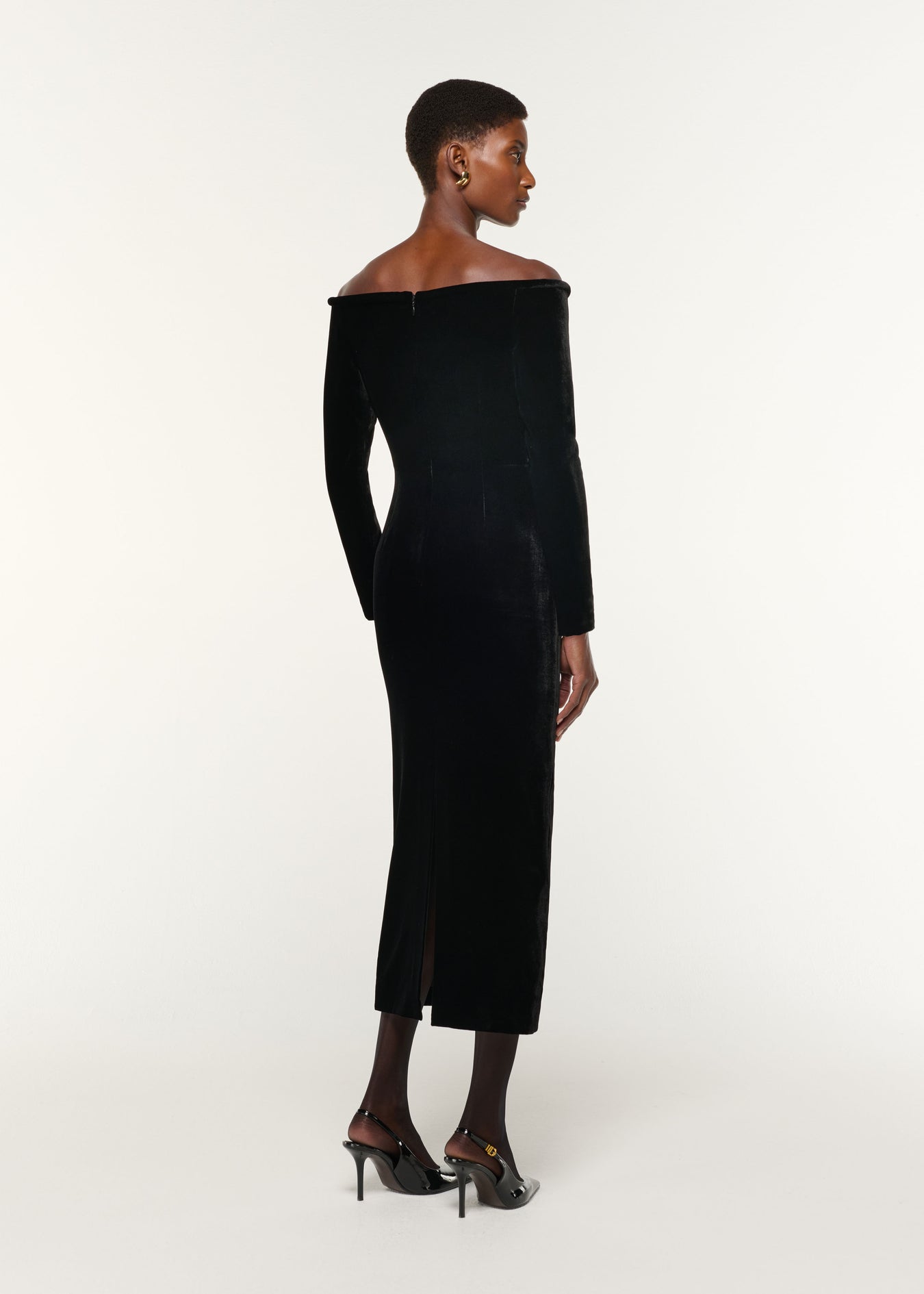 Back view of a model wearing the Plunge Neck Velvet Midi Dress in Black