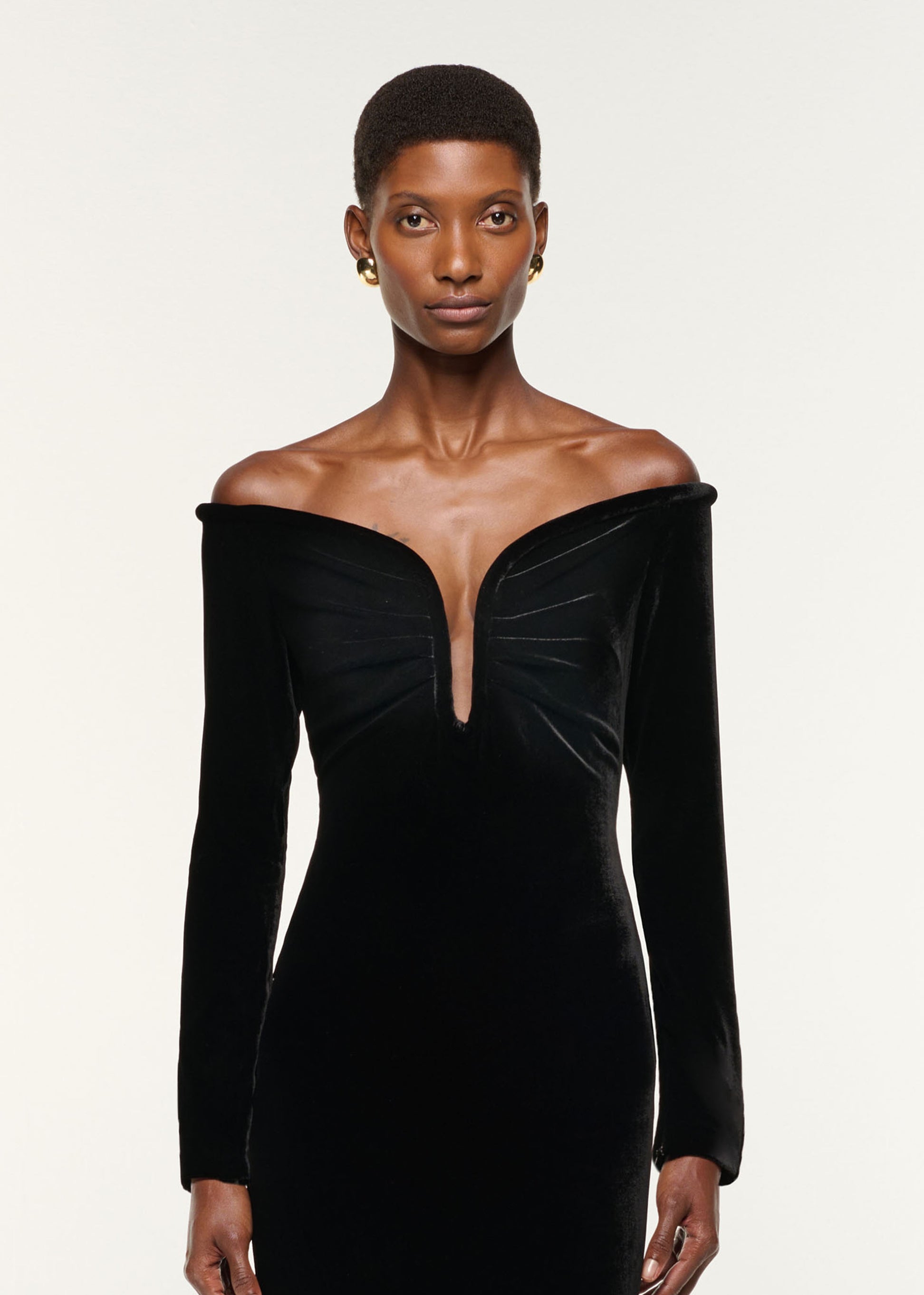 Close up of a model wearing the Plunge Neck Velvet Midi Dress in Black