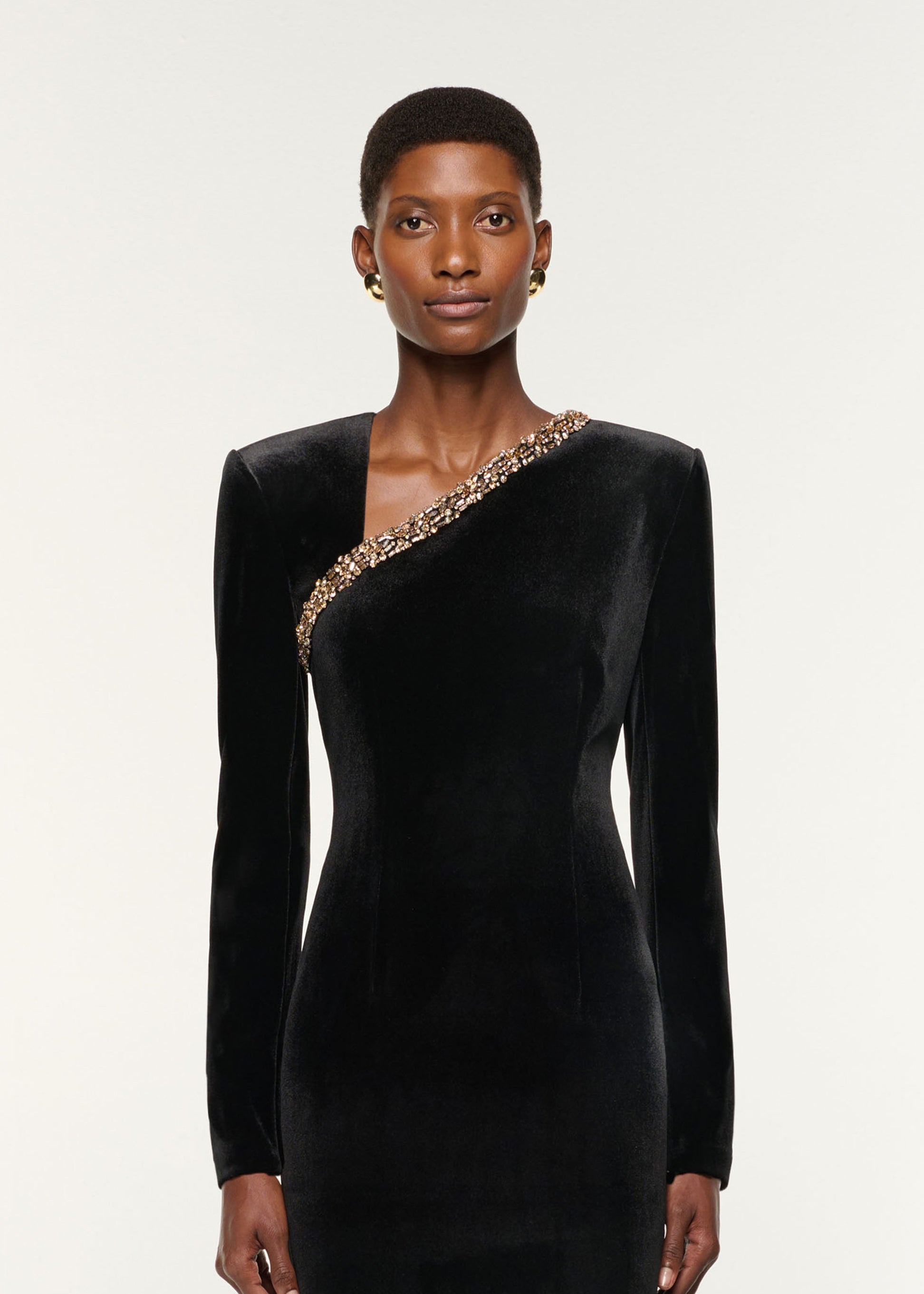 Close up of a model wearing the Long Sleeve Embellished Velvet Gown in Black