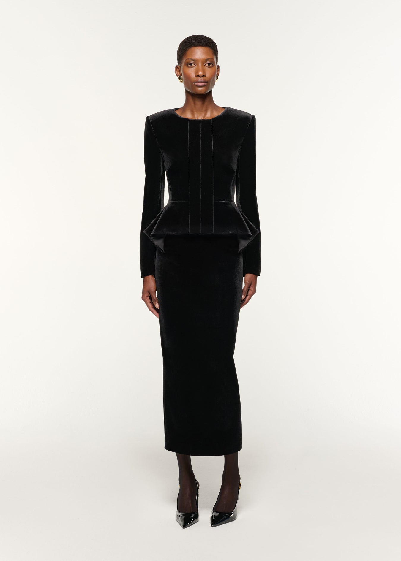Front view of a model wearing the Velvet Peplum Jacket in Black