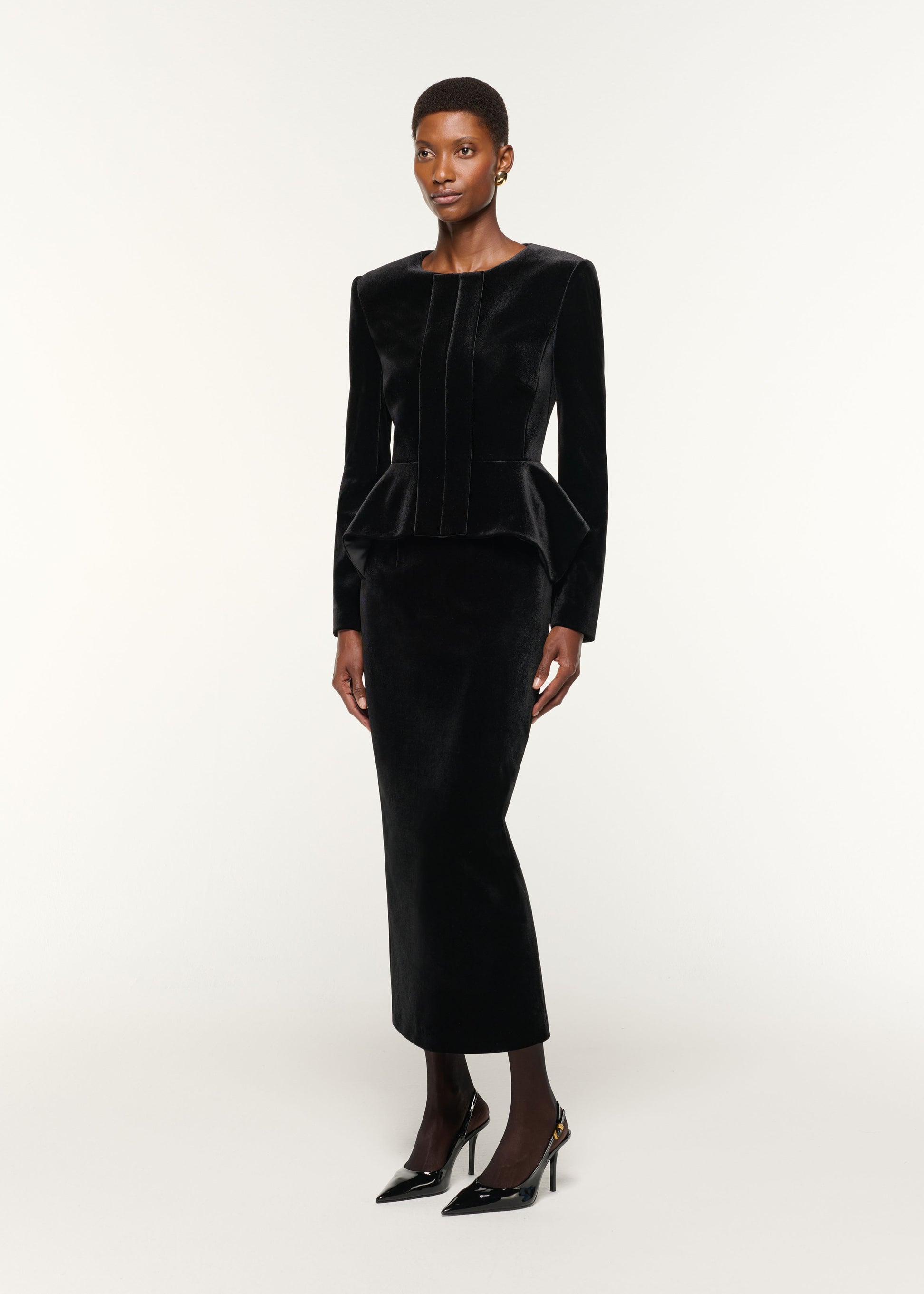 Side view of a model wearing the Velvet Midi Skirt in Black