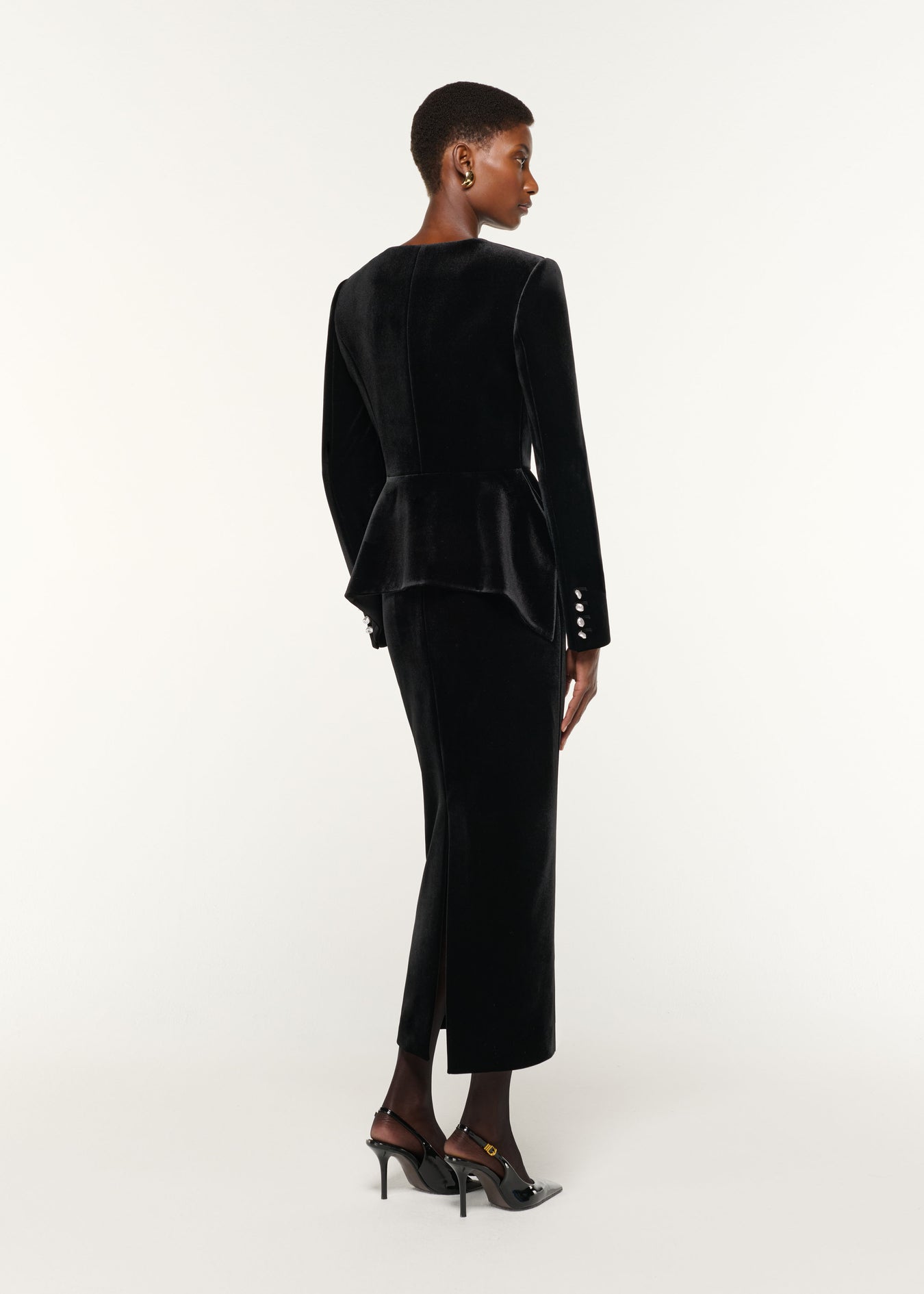 Back view of a model wearing the Velvet Midi Skirt in Black