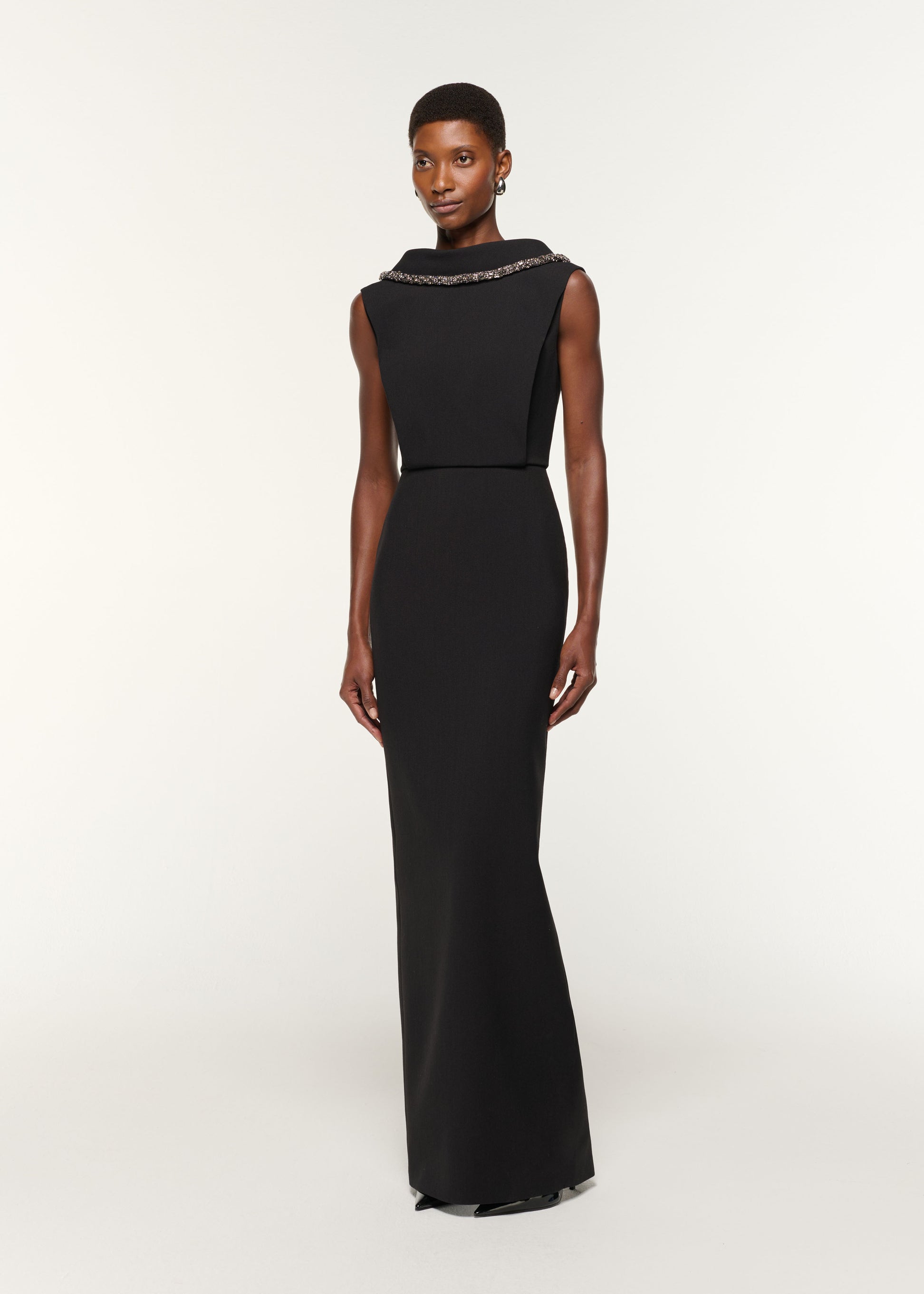 Side view of a model wearing the Diamante Roll Neck Crepe Gown in Black