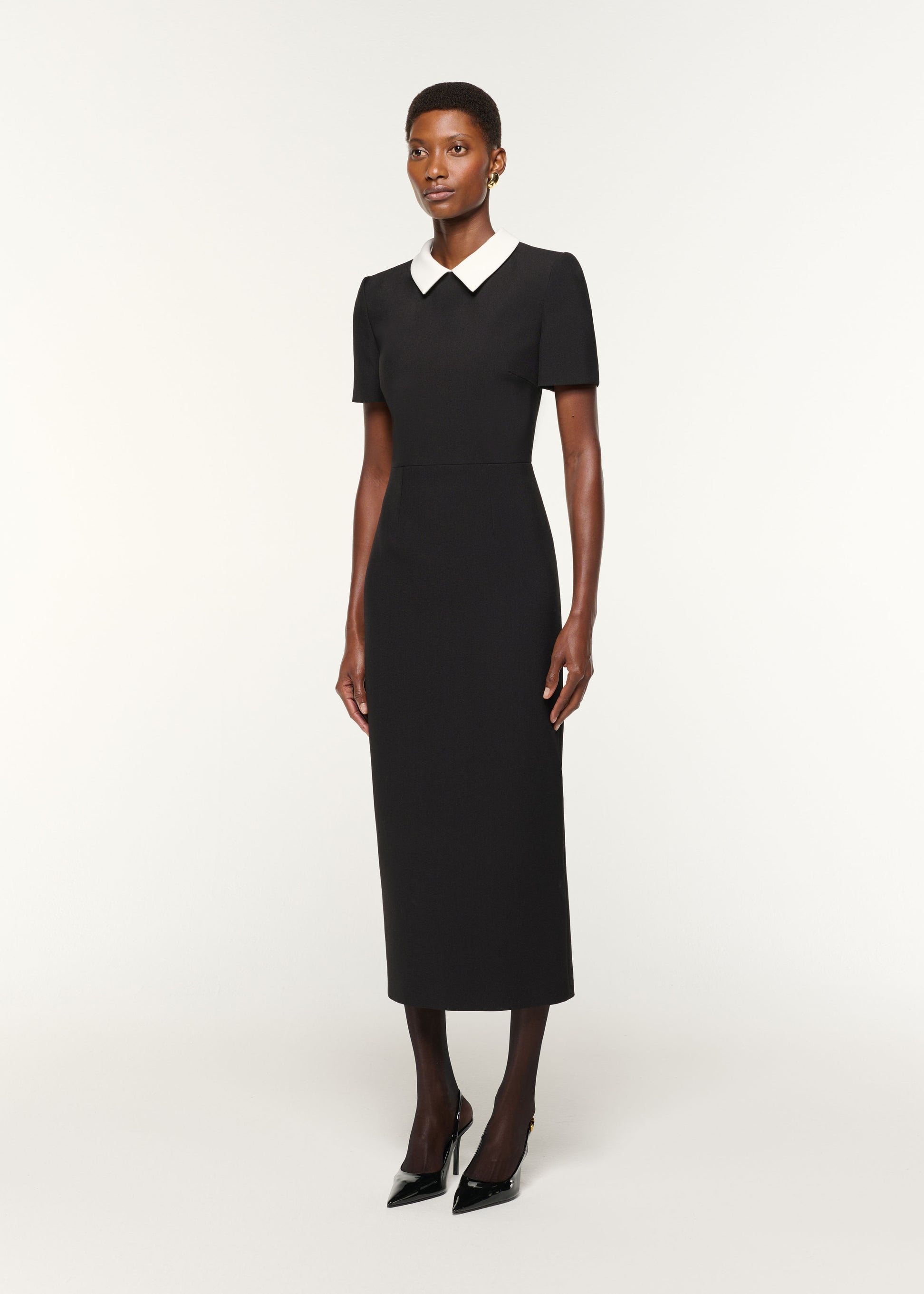 Side view of a model wearing the Contrast Collar Crepe Midi Dress in Black