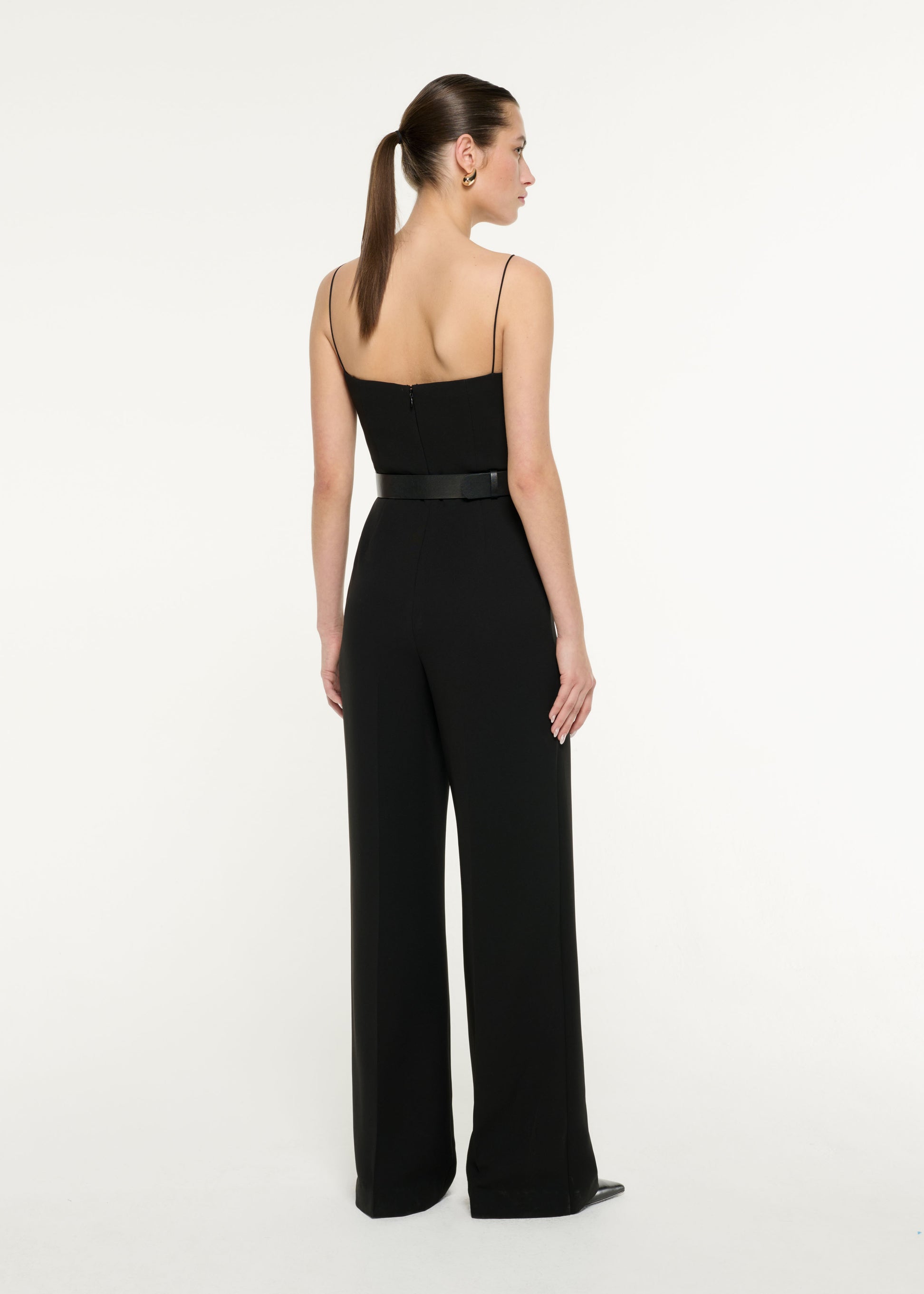 Back view of a model wearing the Diamante Panel Jumpsuit in Black