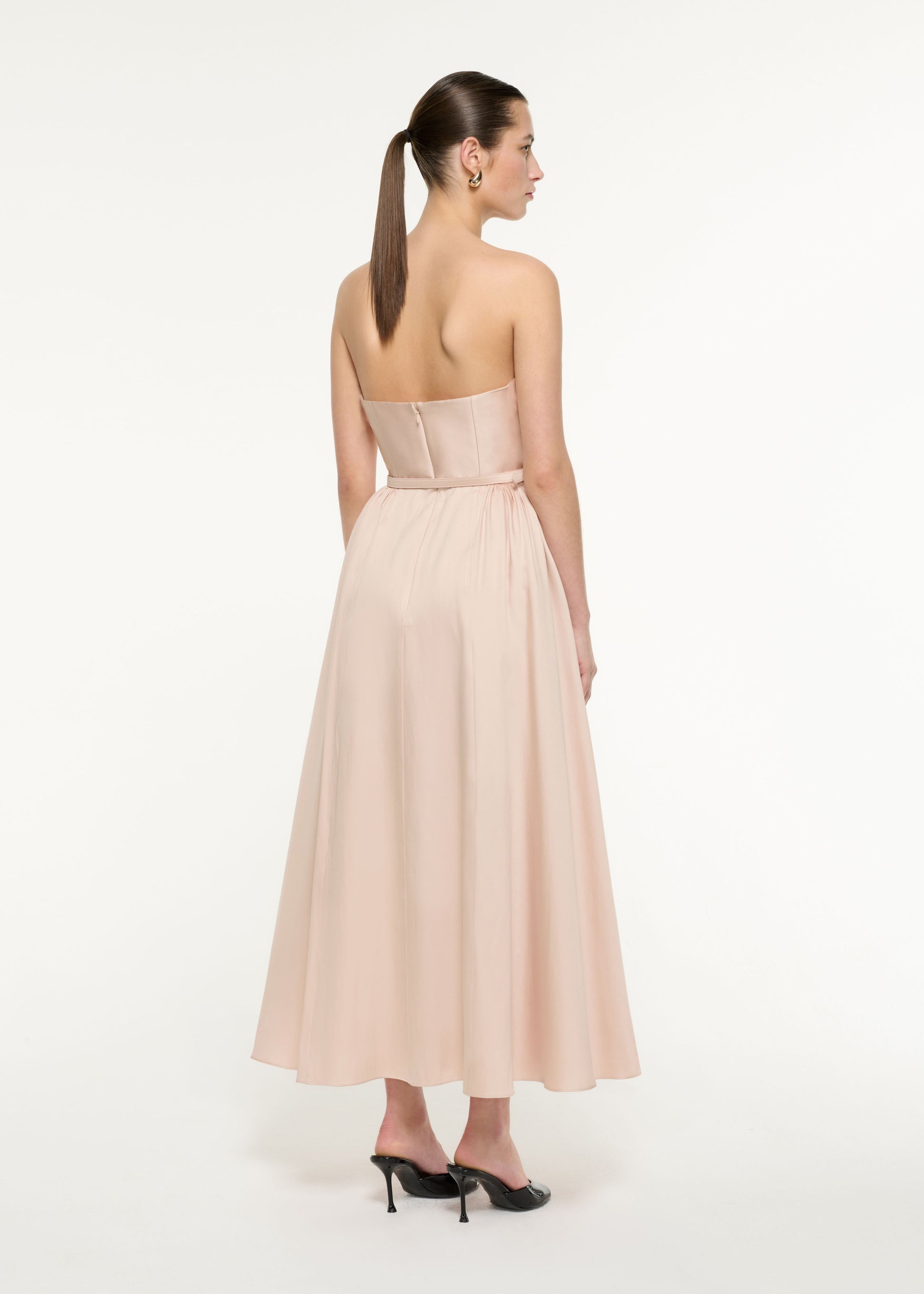 Back view of a model wearing the Ruffle Midi Dress in Nude