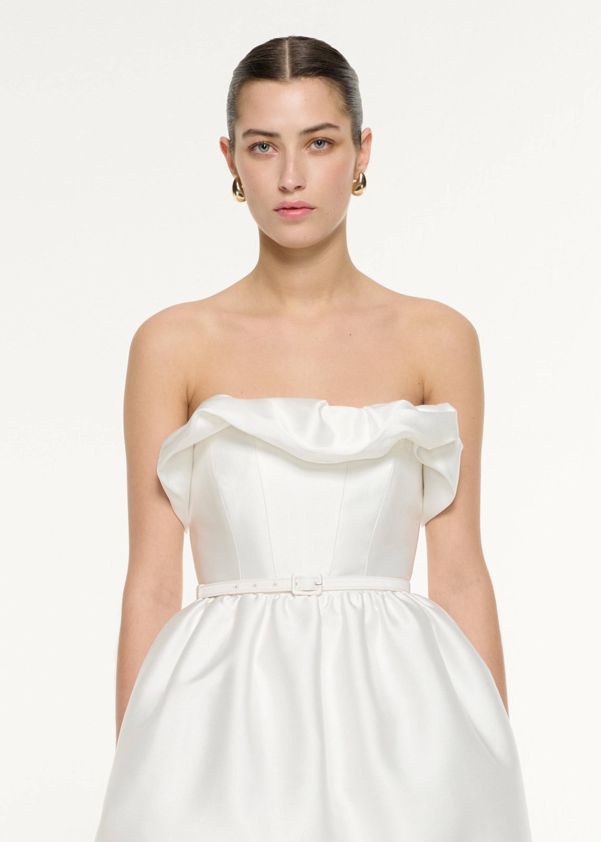 Close up of a model wearing the Ruffle Mini Dress in White