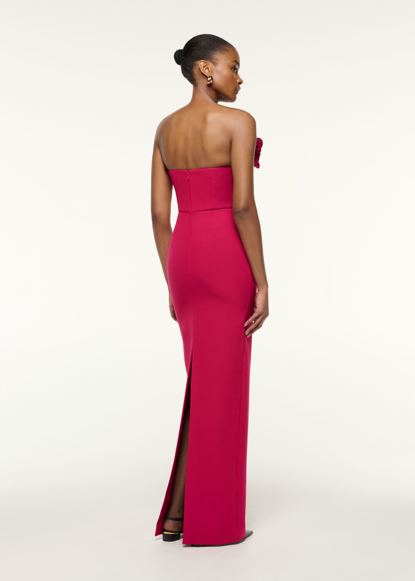 Back view of a model wearing the Flower Detail Strapless Evening Gown in Hot Pink