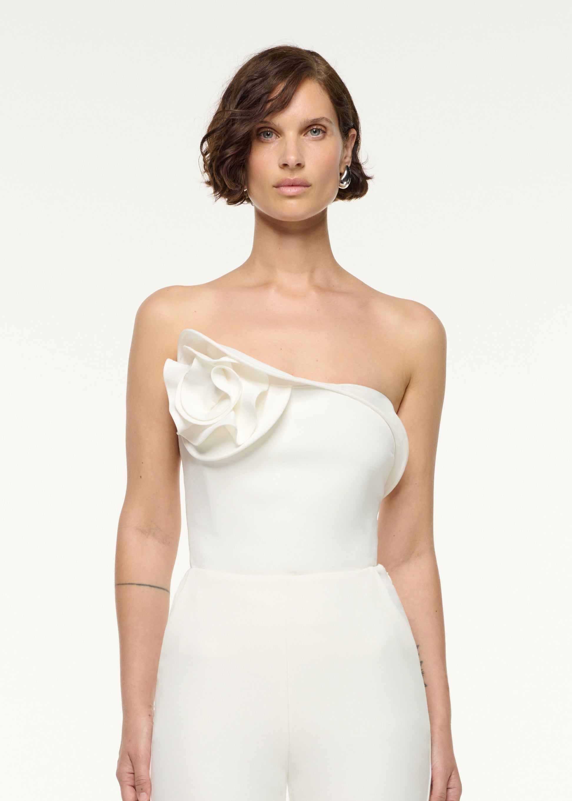 Close up of a model wearing the Flower Detail Strapless Top in White