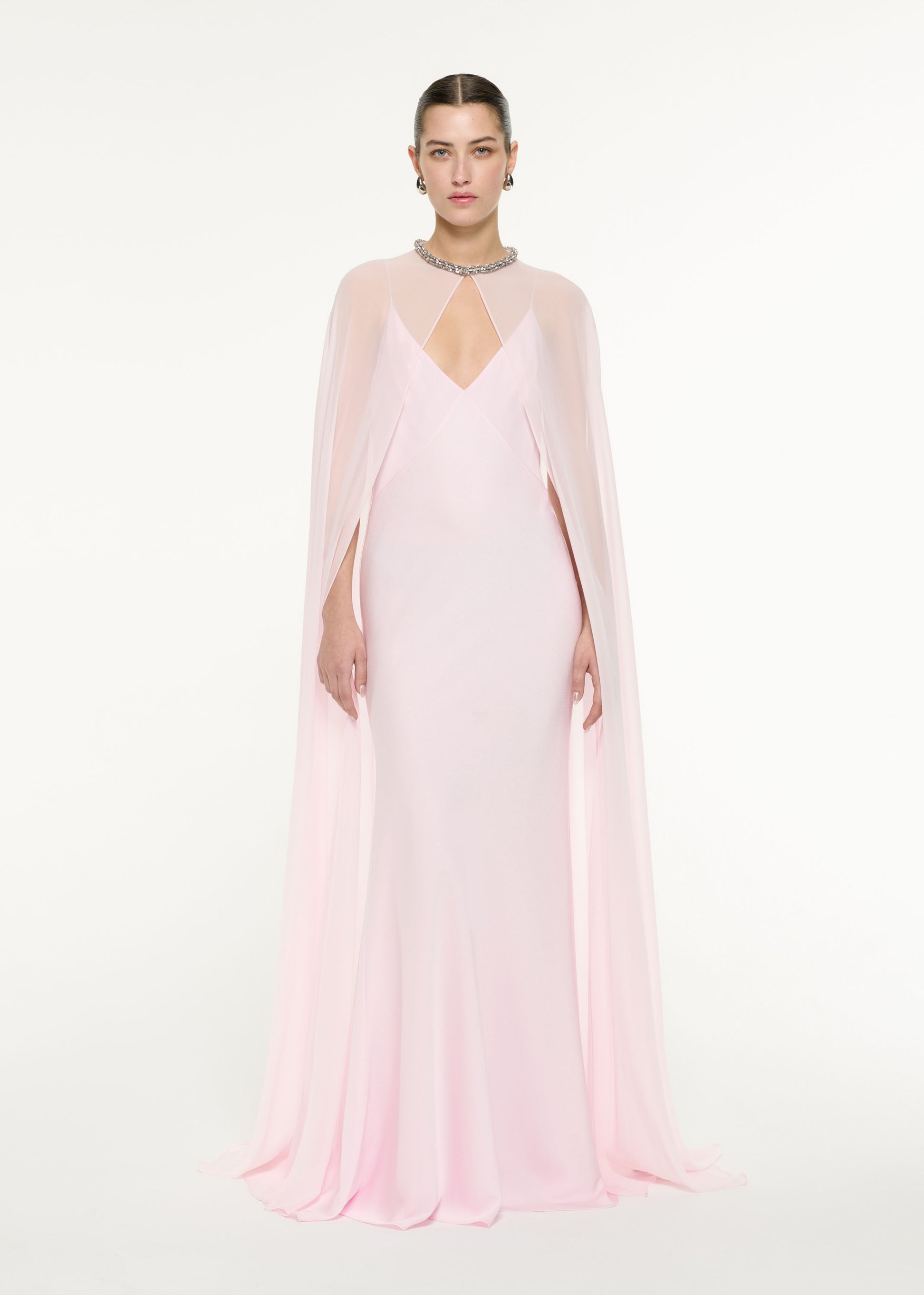 Front view of a model wearing the Satin Crepe Cape Gown in Light Pink