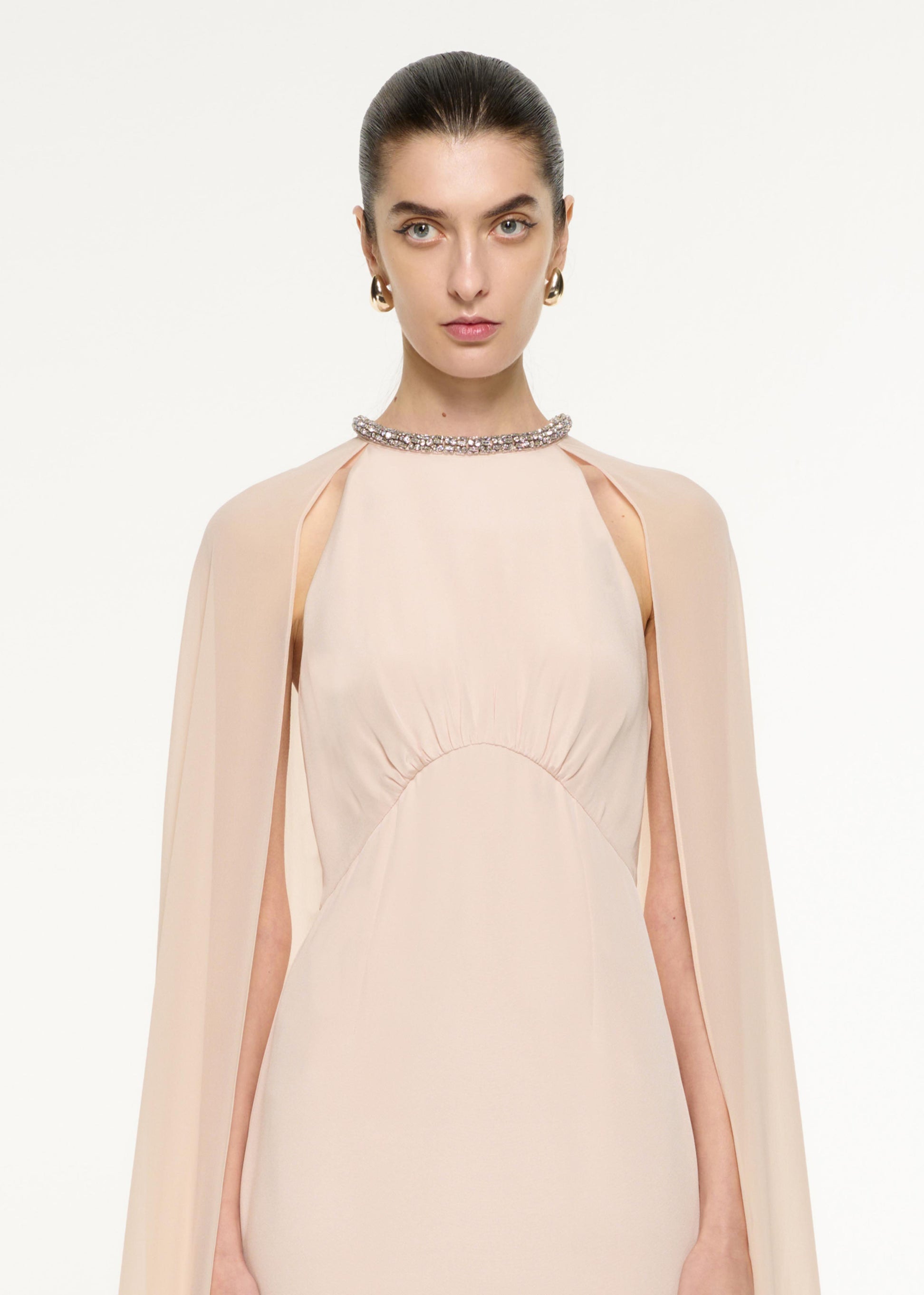 Close up of a model wearing the Silk Chiffon Cape Dress in Nude