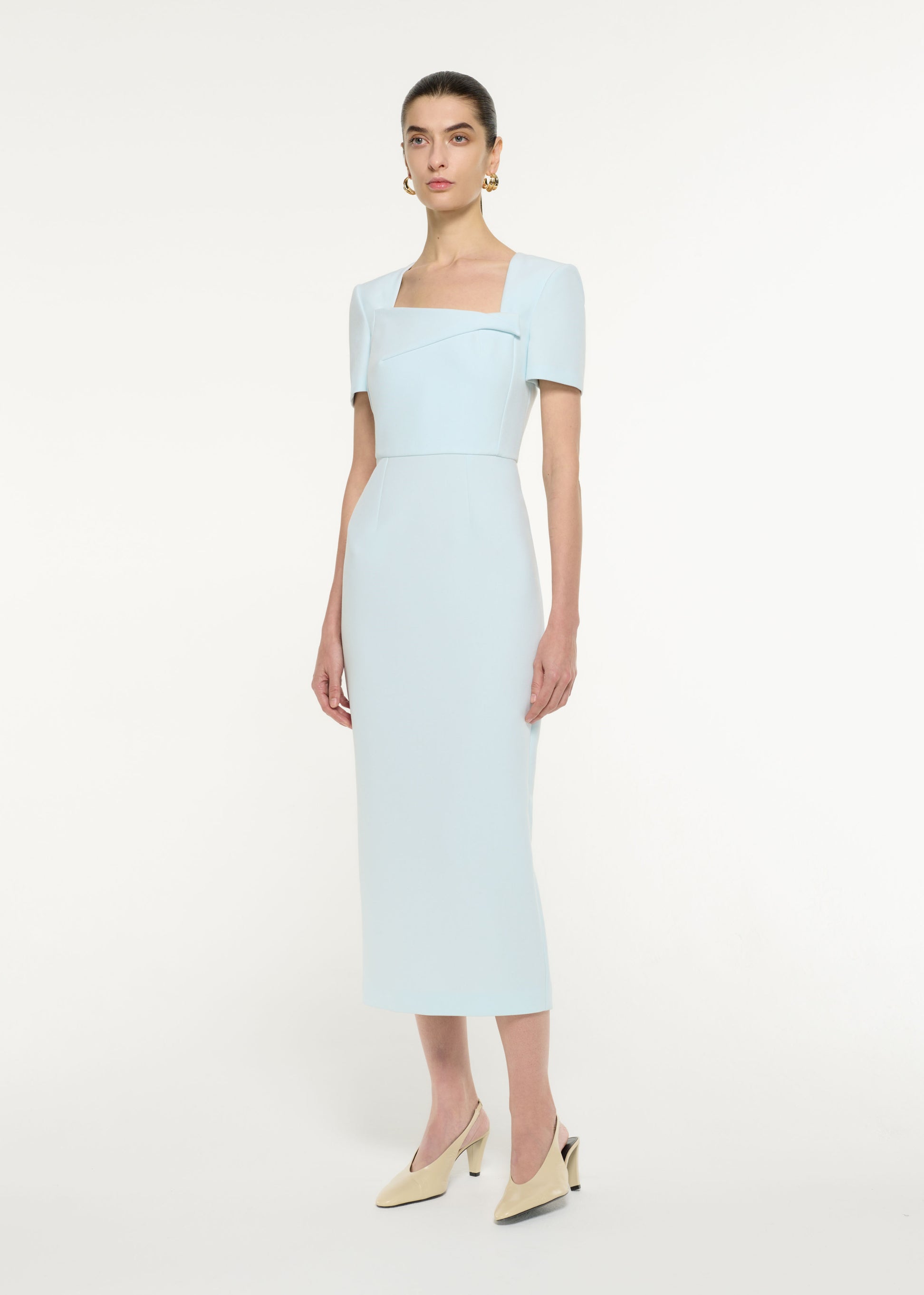 Side view of a model wearing the Asymmetric Drape Midi Dress in Blue