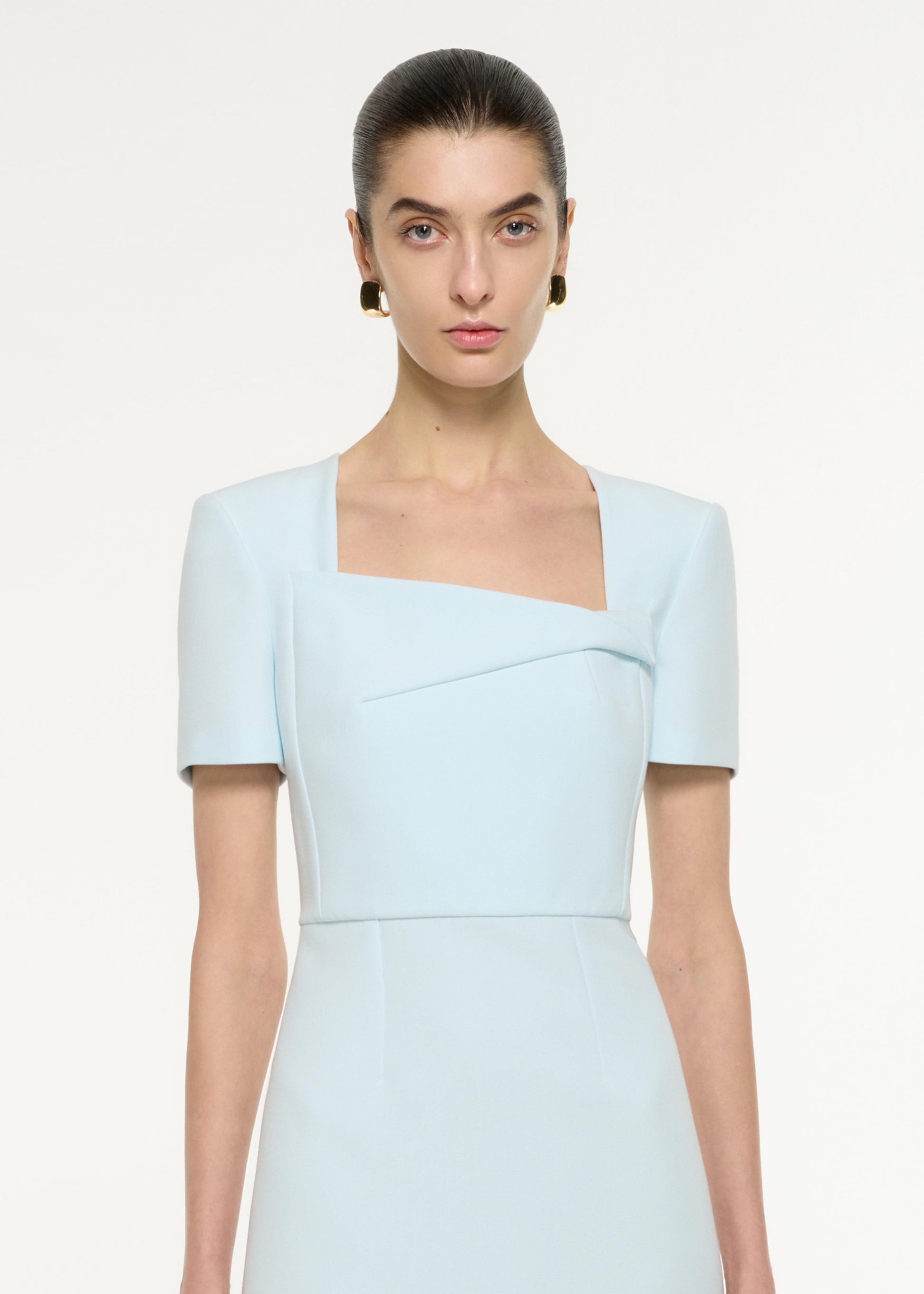 Close up of a model wearing the Asymmetric Drape Midi Dress in Blue