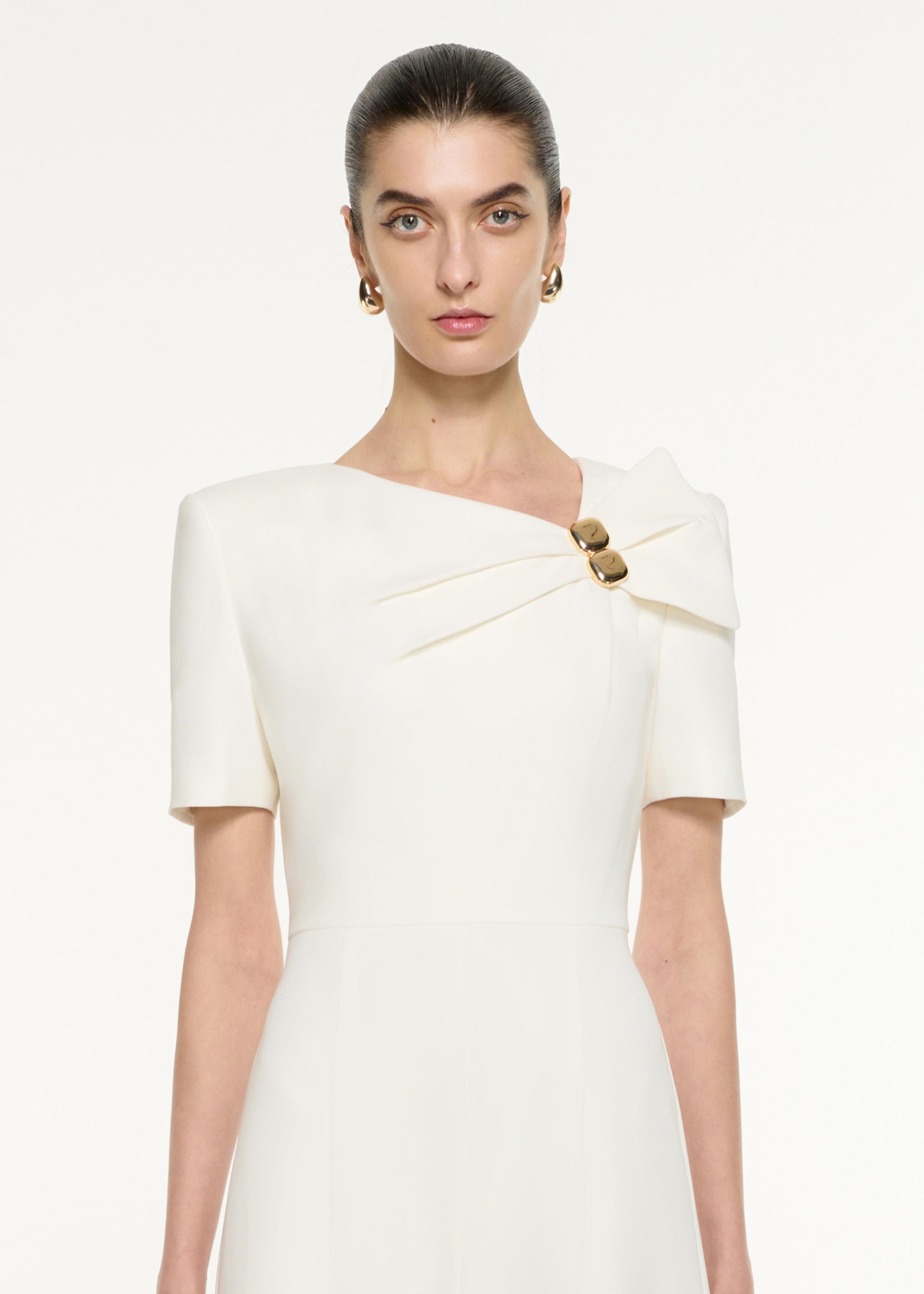 Close up of a model wearing the Bow Drape Light Cady Midi Dress in Cream