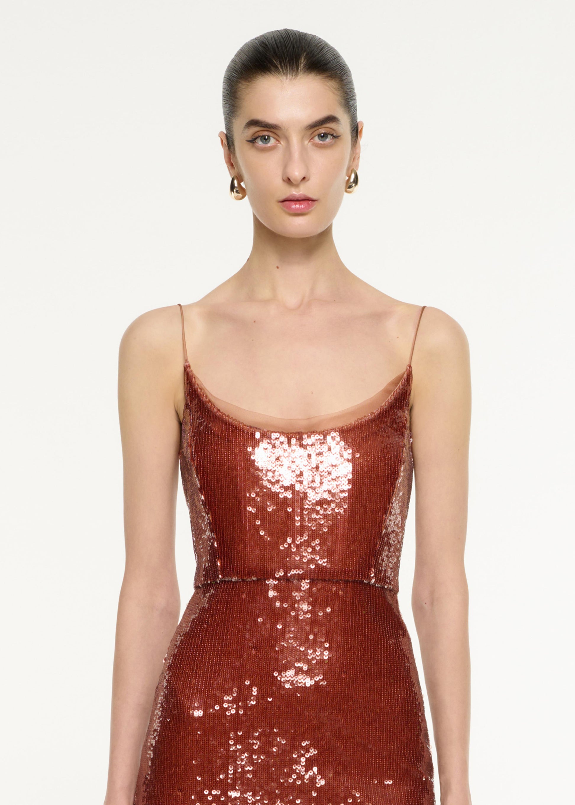 Close up of a model wearing the Sequin Midi Dress in Copper