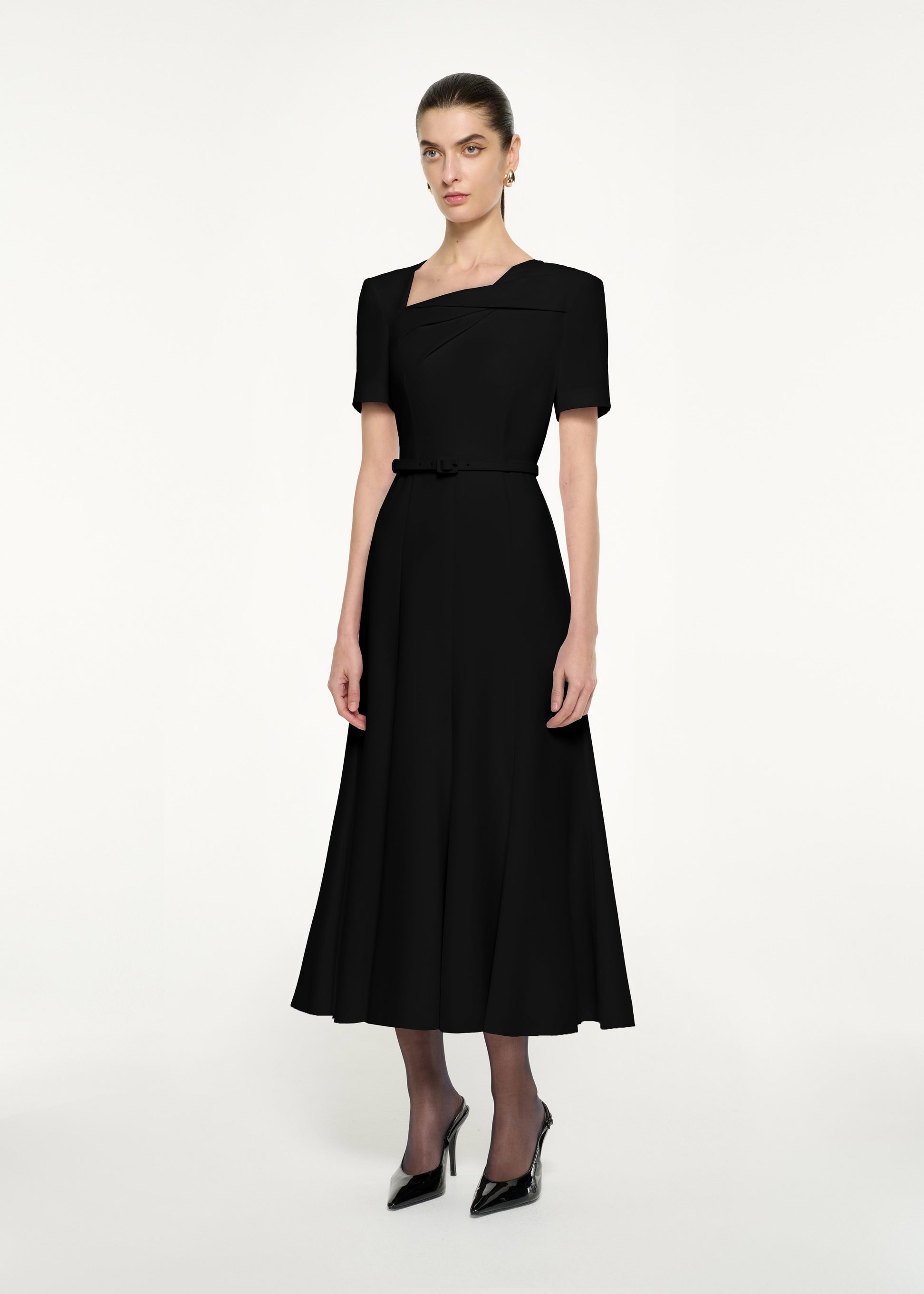 Side view of a model wearing the Short Sleeve Twist Drape Midi Dress in Black