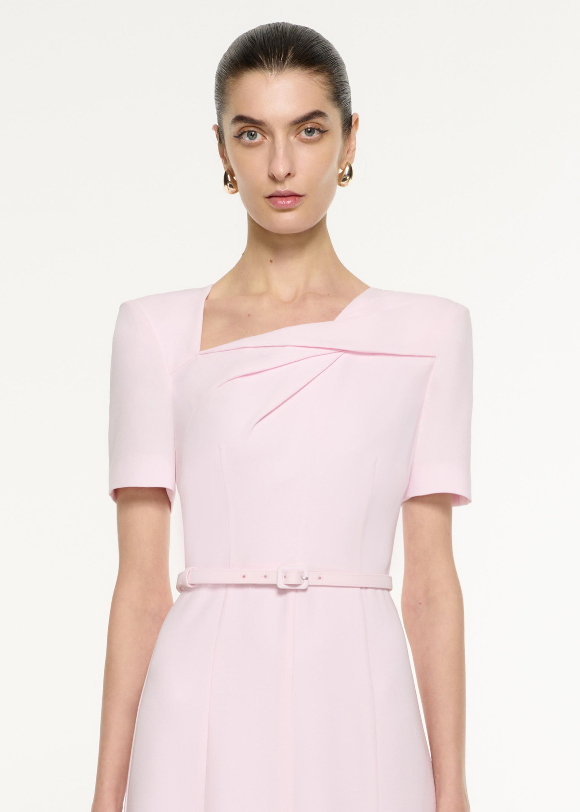 Close up of a model wearing the Tri-fold Drape Midi Dress in Light Pink