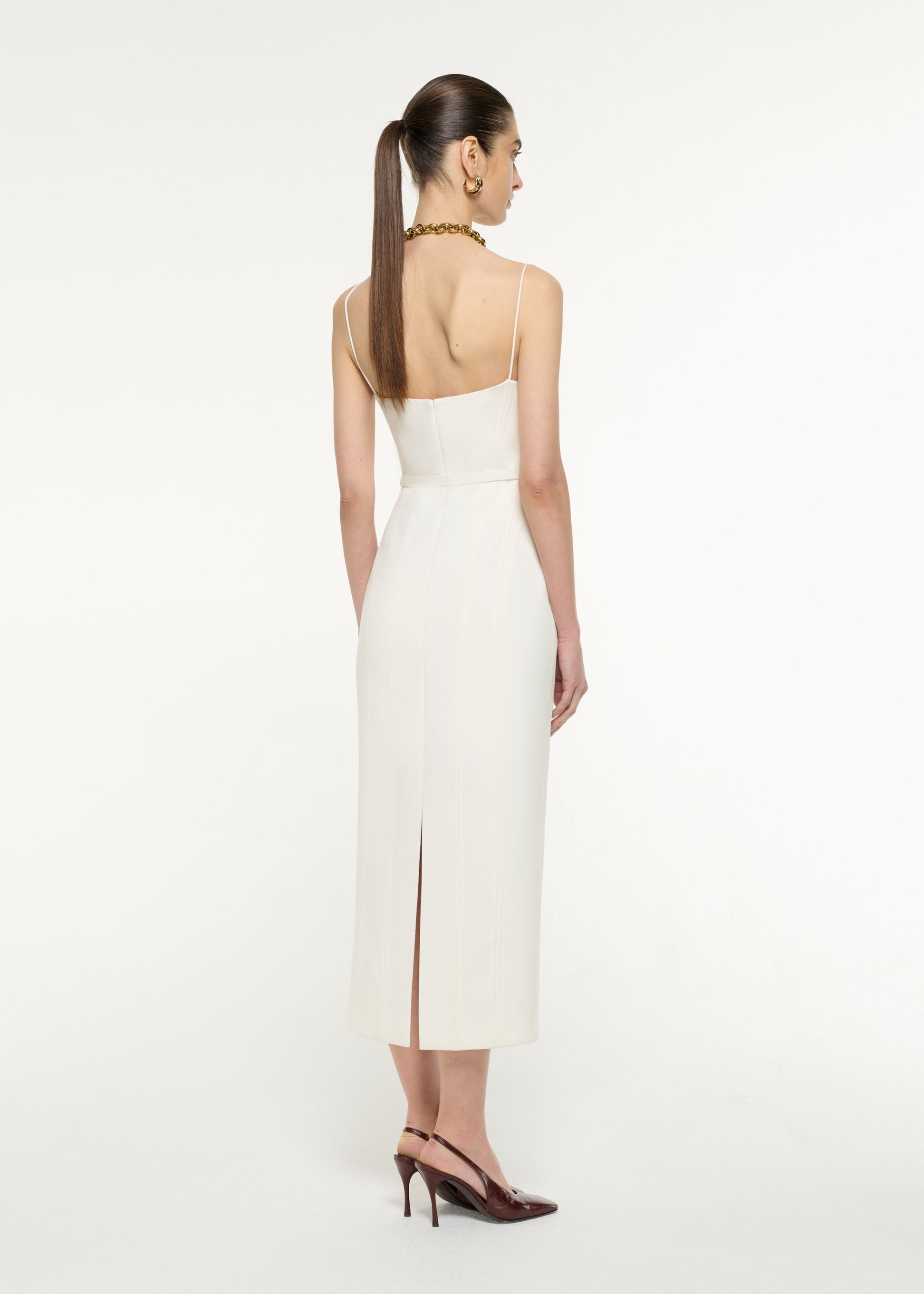 Back view of a model wearing the Crepe Tailored Midi Dress in Cream