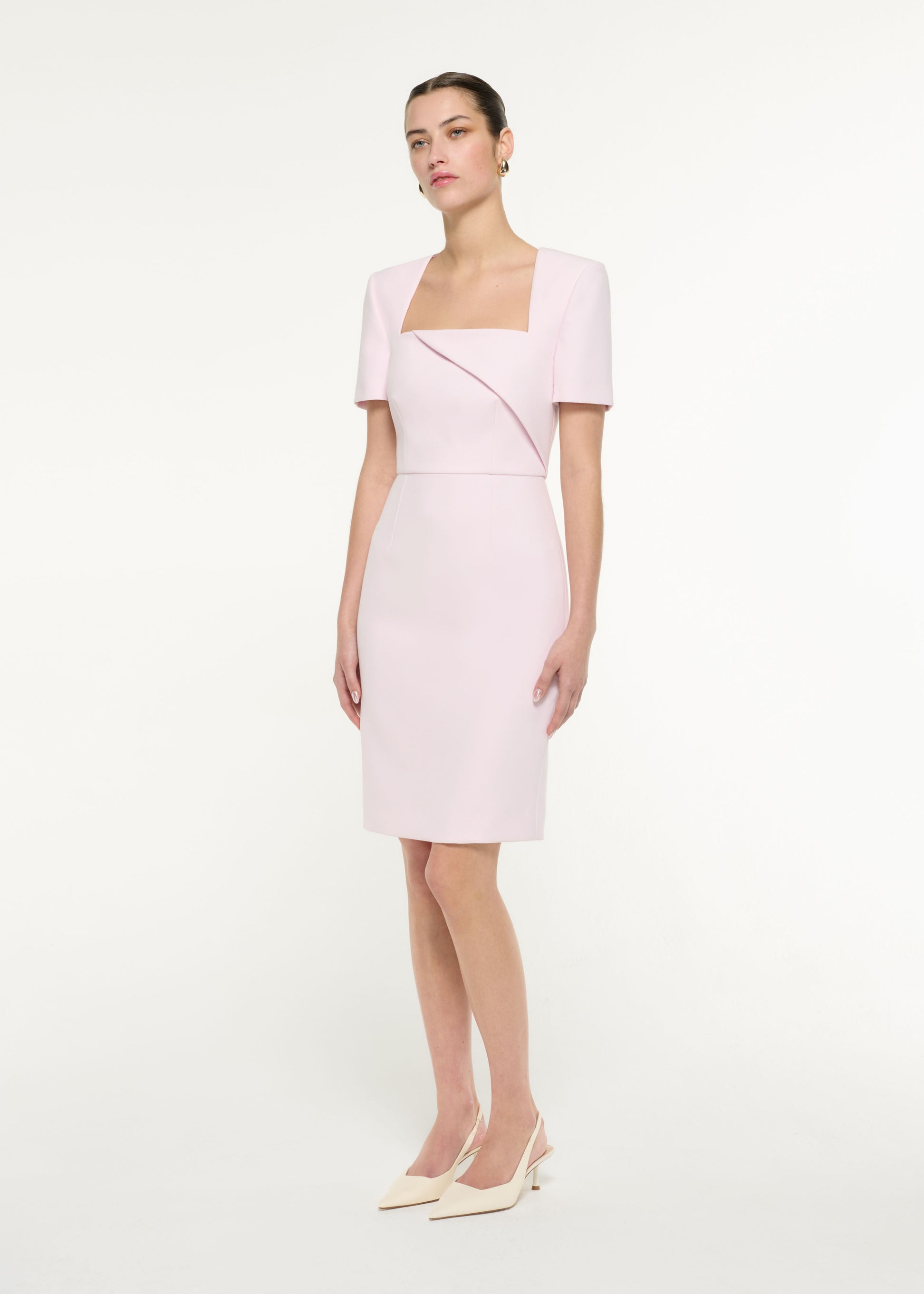 Side view of a model wearing the Diagonal Fold Midi Dress in Light Pink