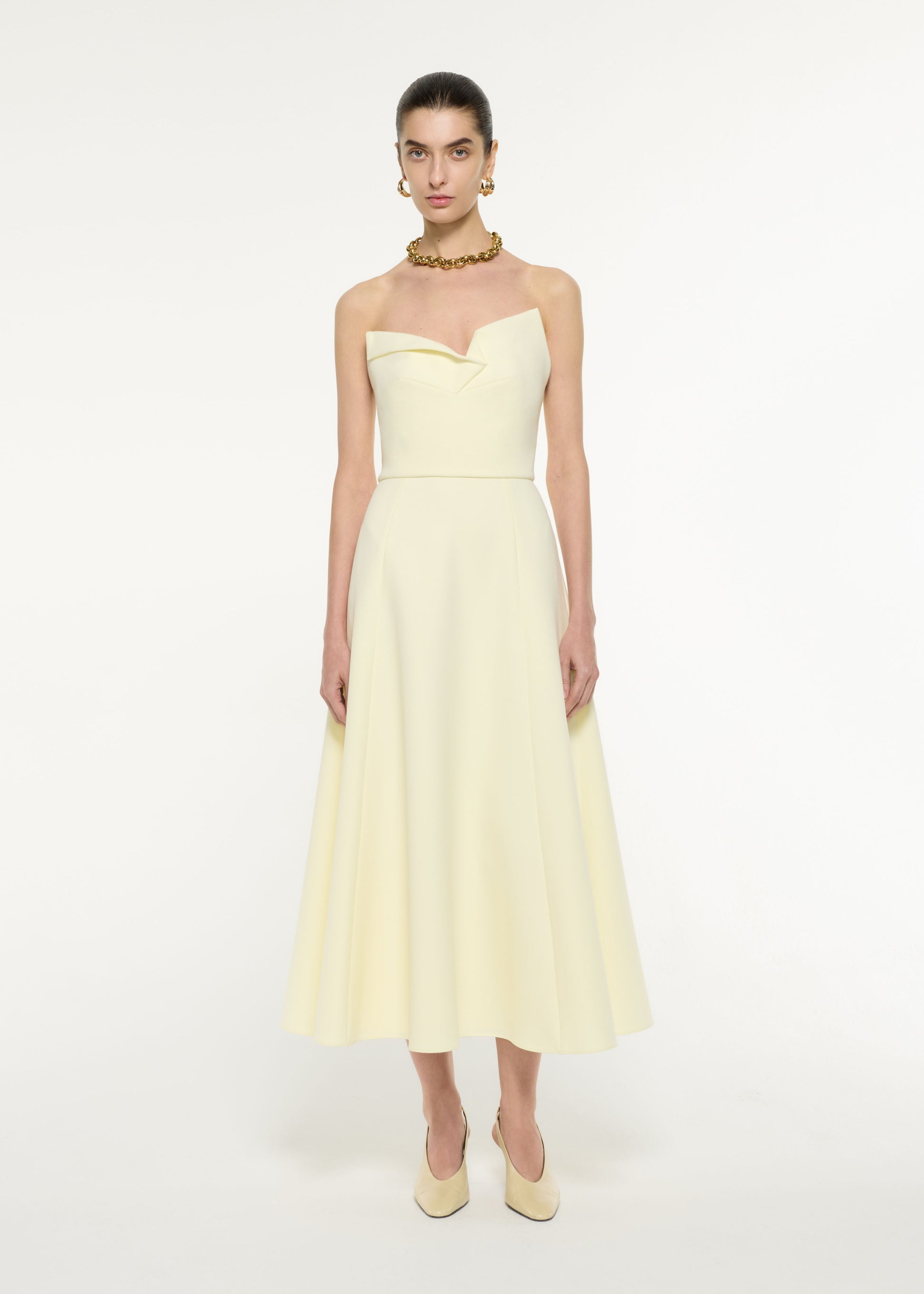 Front view of a model wearing the Strapless Drape Crepe Midi Dress in Light Yellow