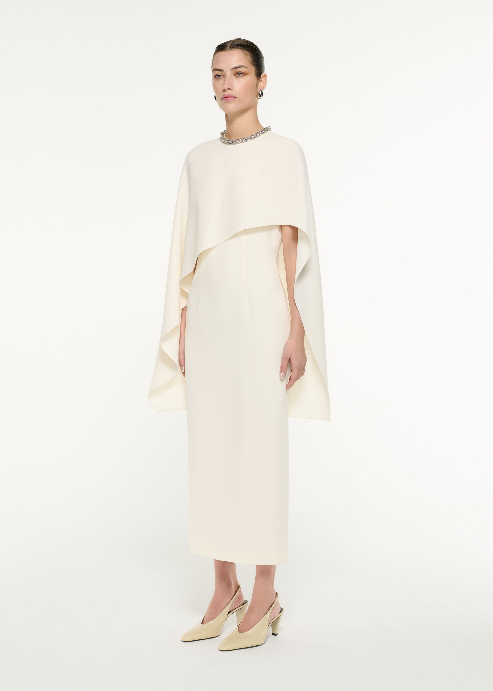 Side view of a model wearing the Heavy Cady Cape Midi Dress in Cream