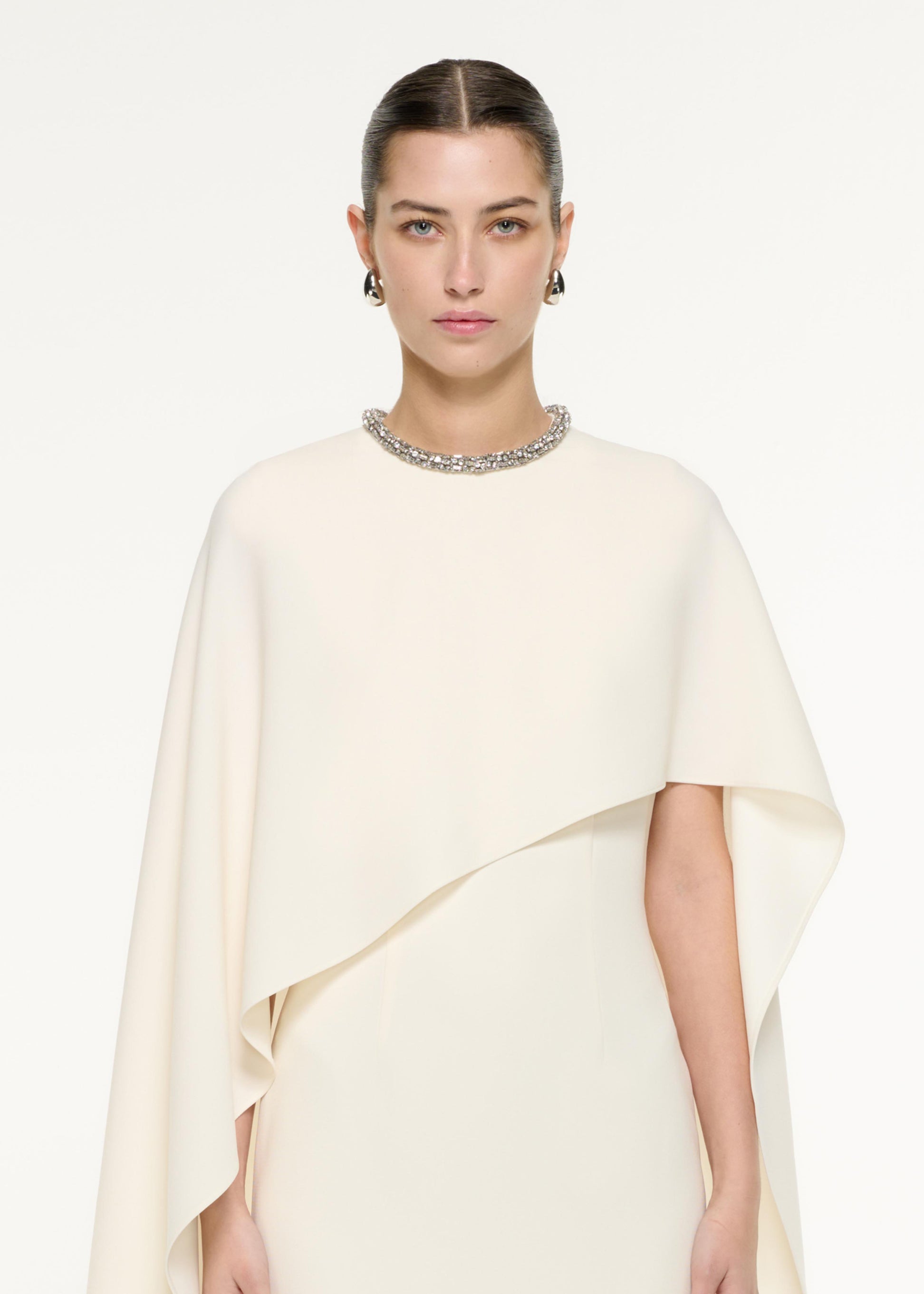 Close up of a model wearing the Heavy Cady Cape Midi Dress in Cream