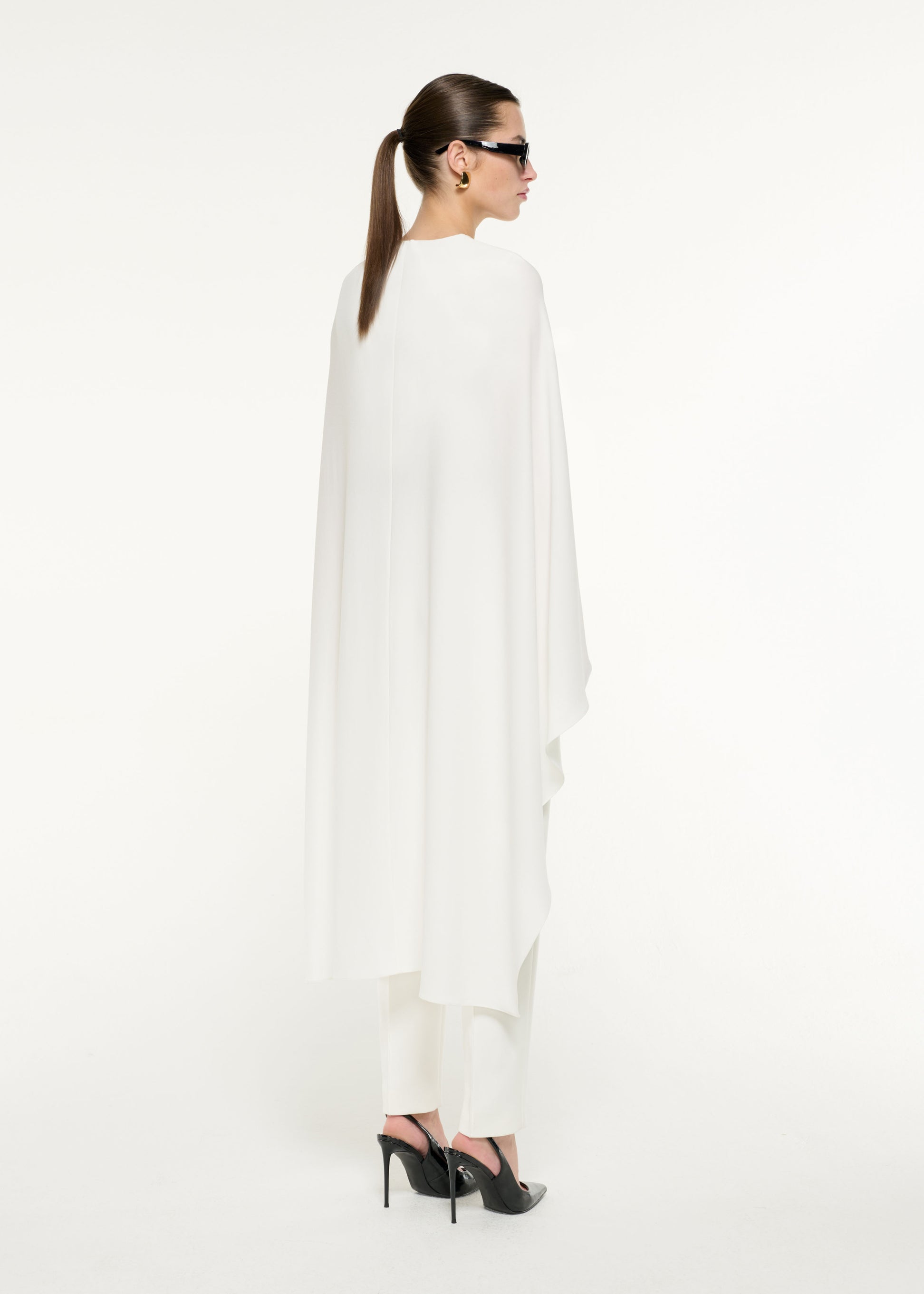 Back view of a model wearing the Satin Crepe Cape Top in White