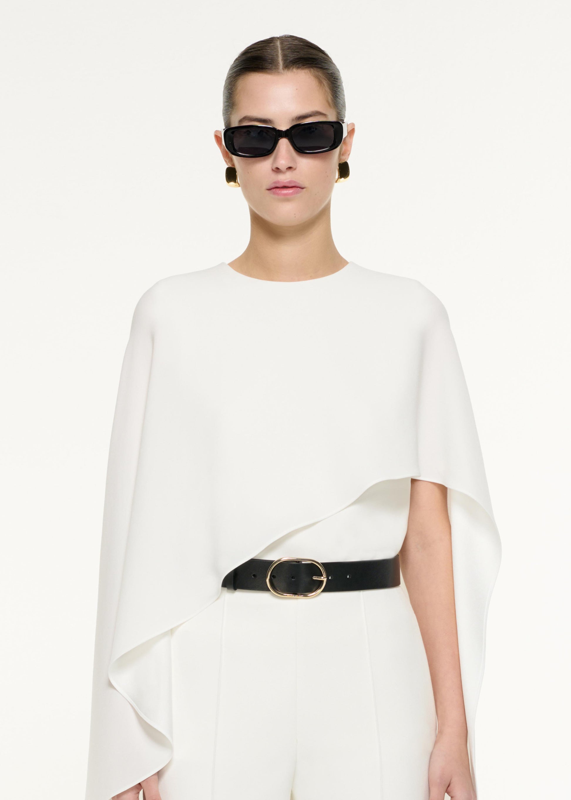 Close up of a model wearing the Satin Crepe Cape Top in White