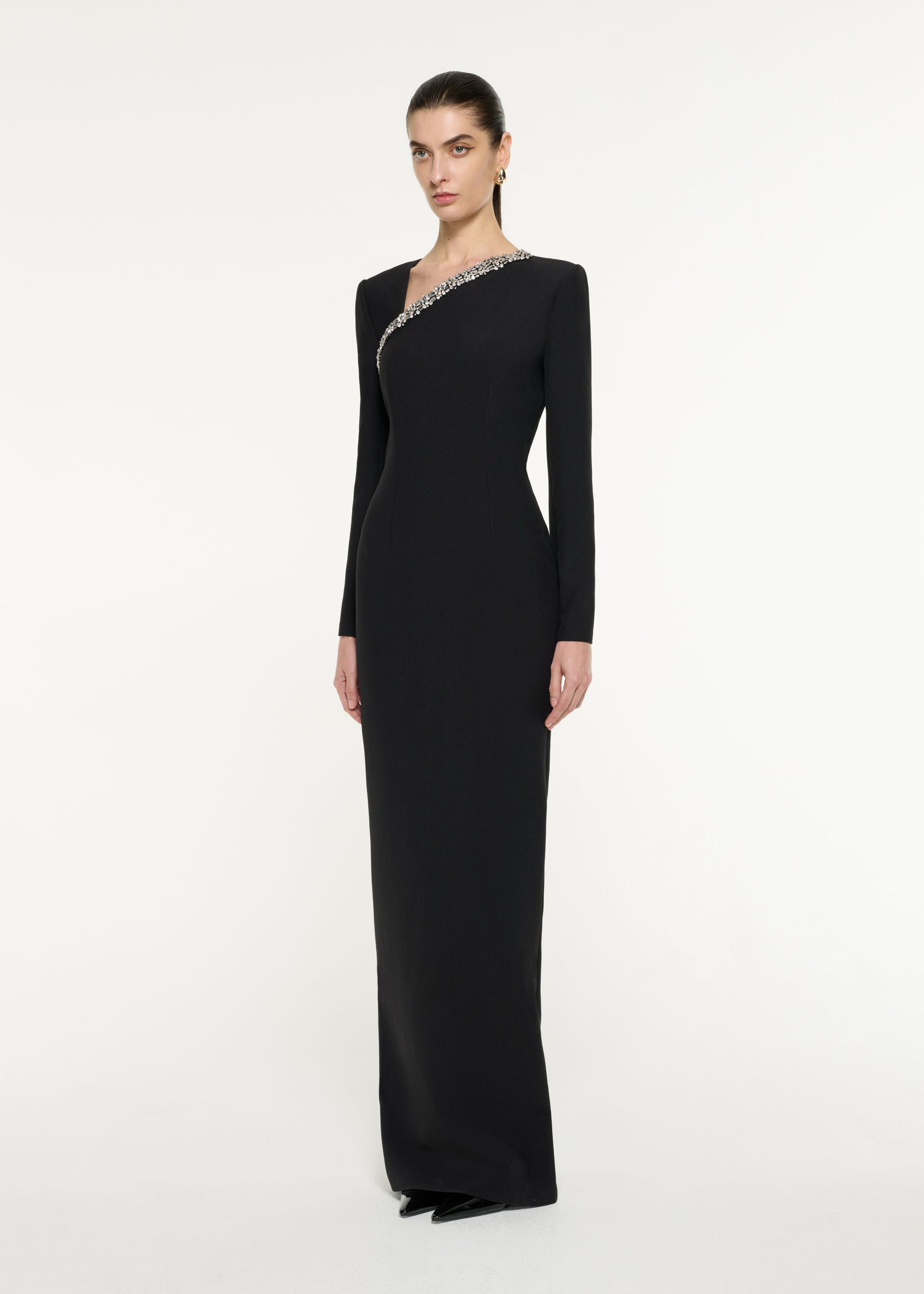 Side view of a model wearing the Embellished Asymmetric Crepe Gown in Black
