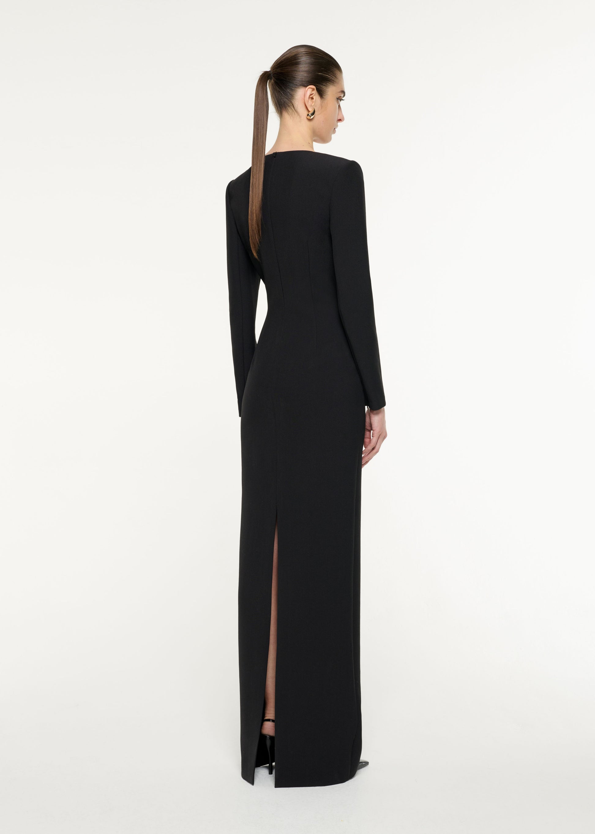 Back view of a model wearing the Embellished Asymmetric Crepe Gown in Black