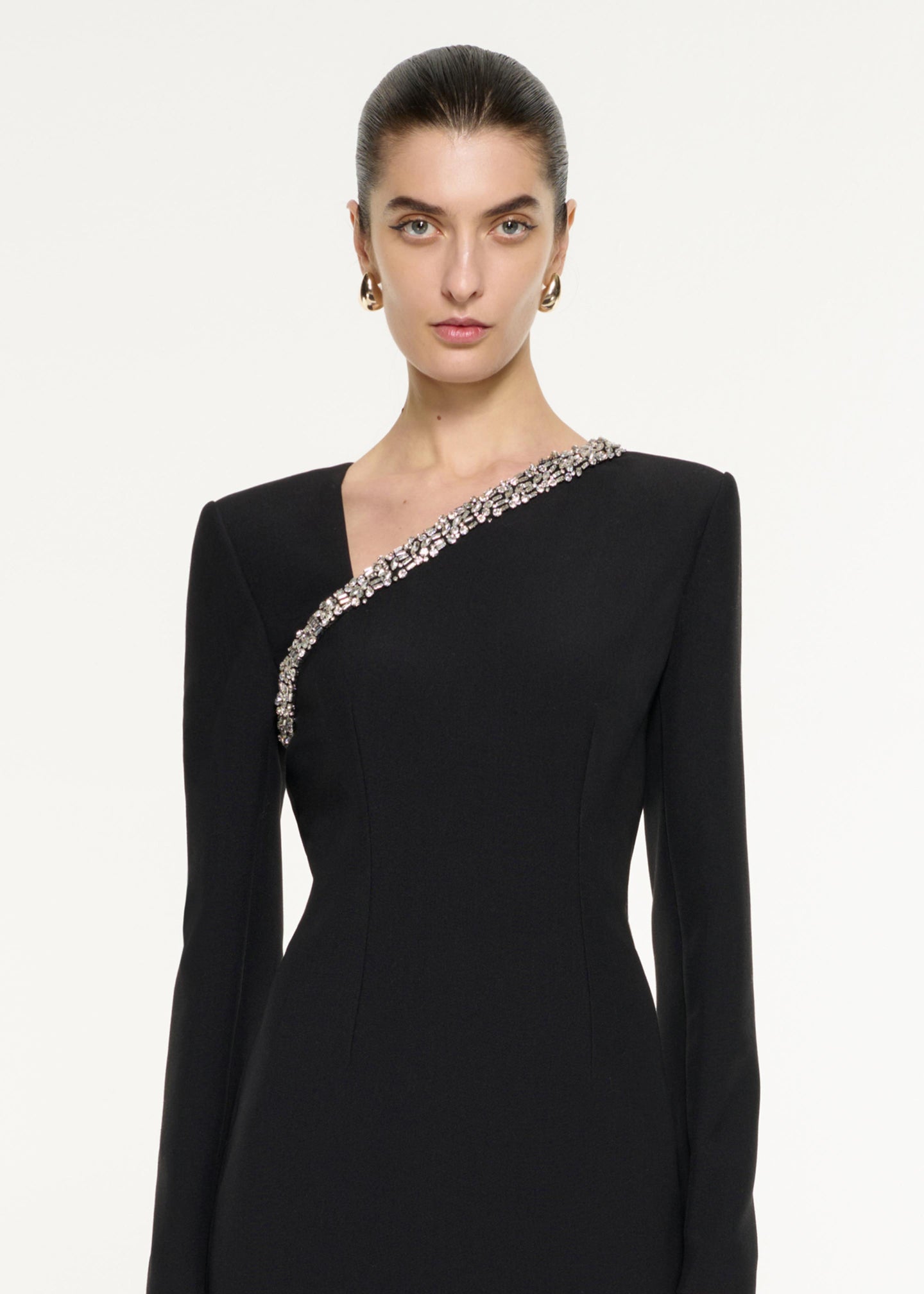 Close up of a model wearing the Embellished Asymmetric Crepe Gown in Black