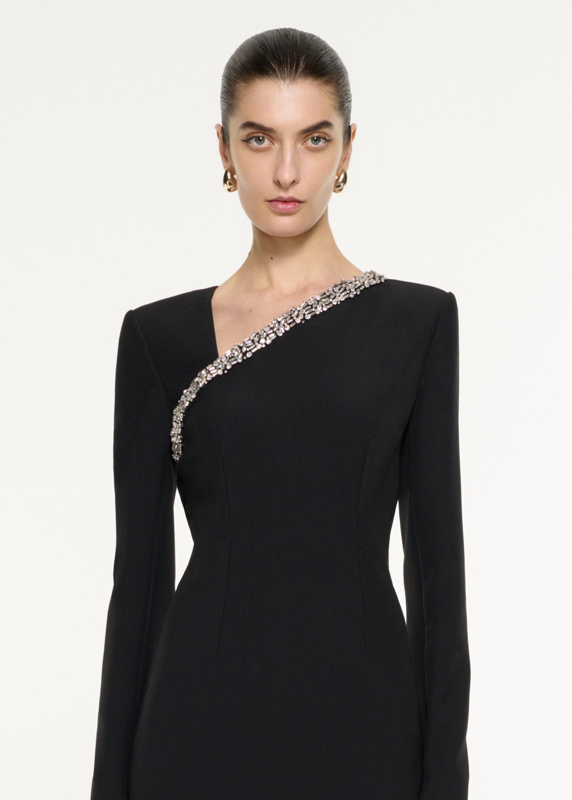 Close up of a model wearing the Embellished Asymmetric Crepe Gown in Black