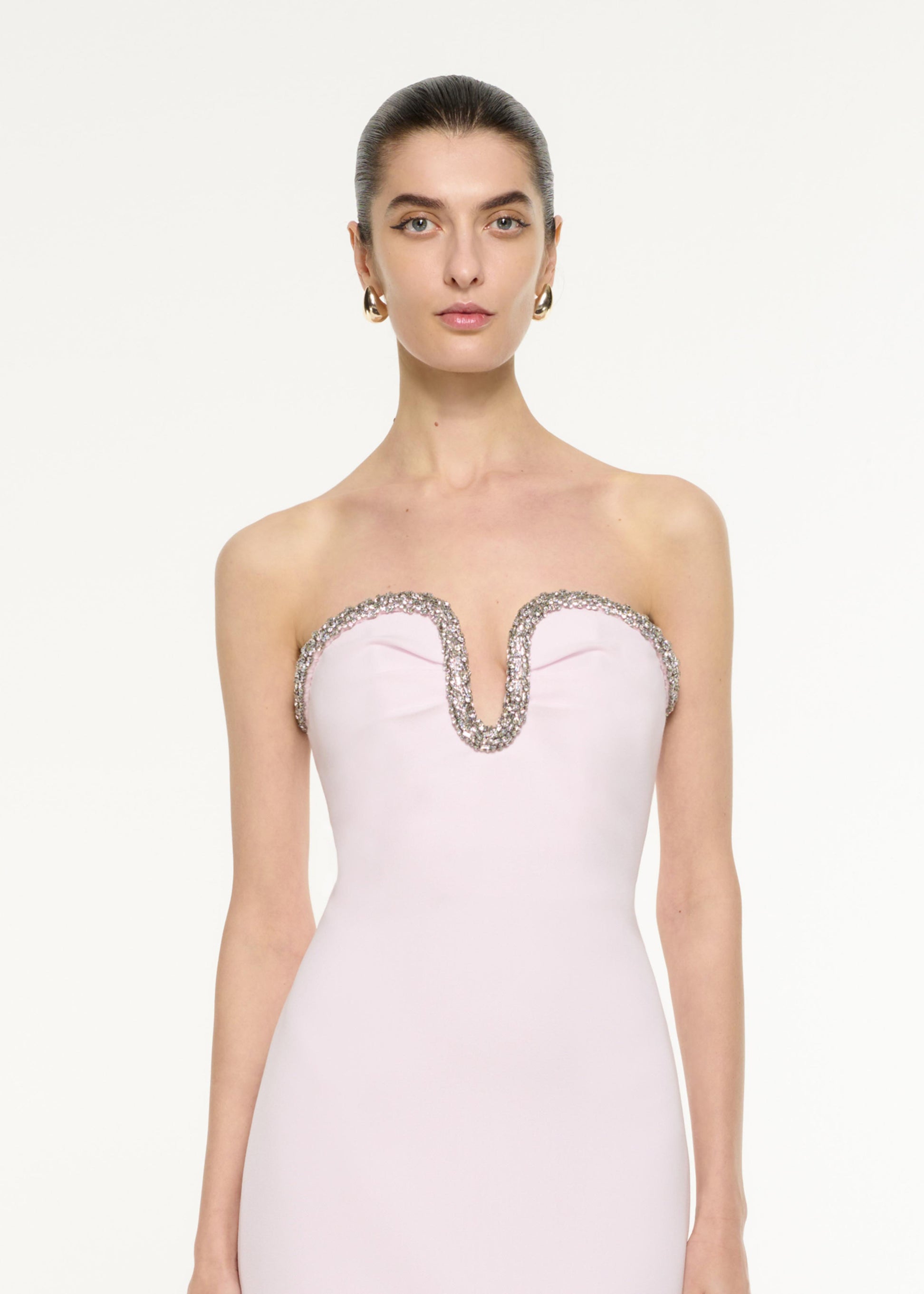 Close up of a model wearing the Sweetheart Embellished Midi Dress in light pink