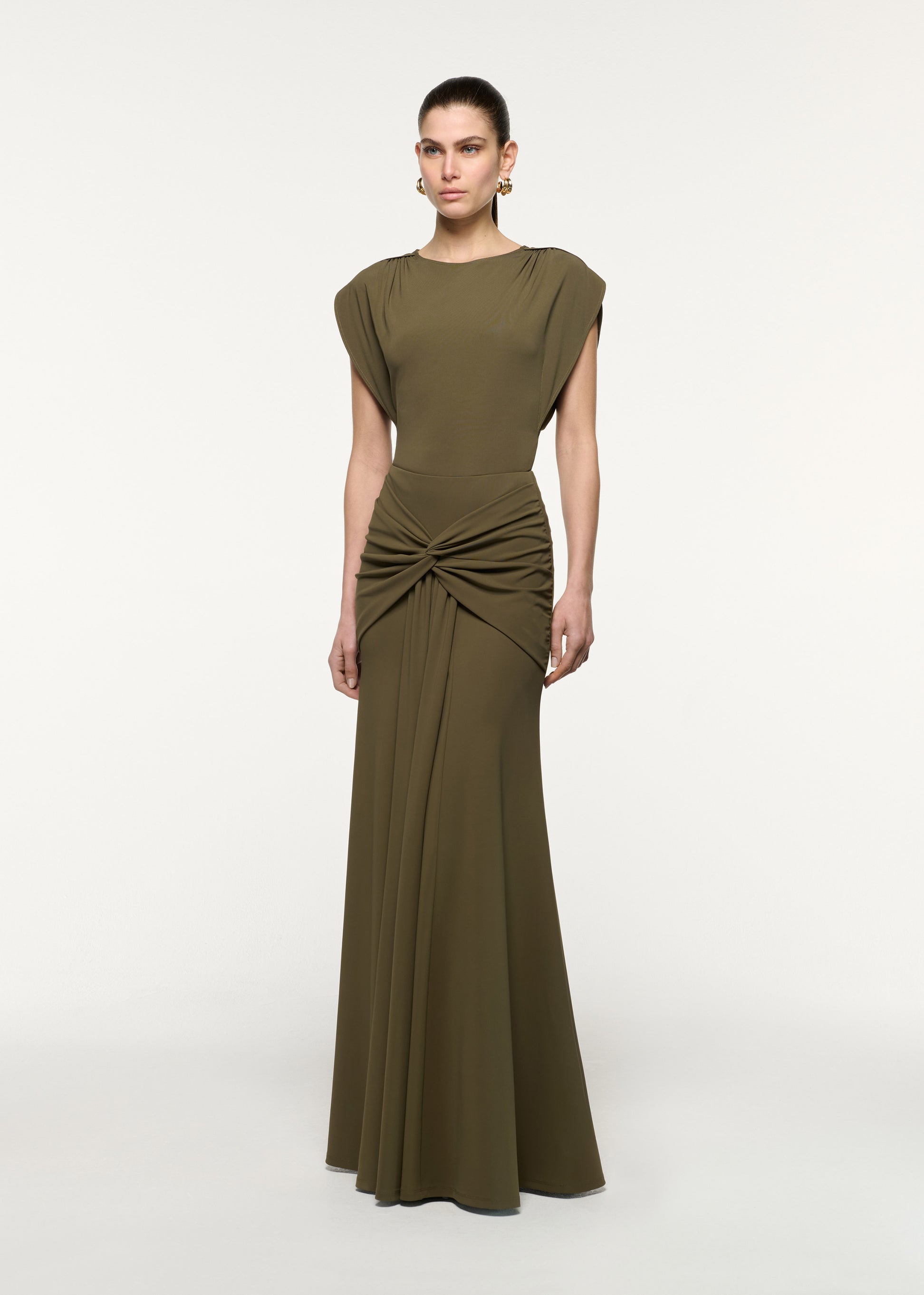 Side view of a model wearing the Waterfall Twist Drape Jersey Skirt in Khaki
