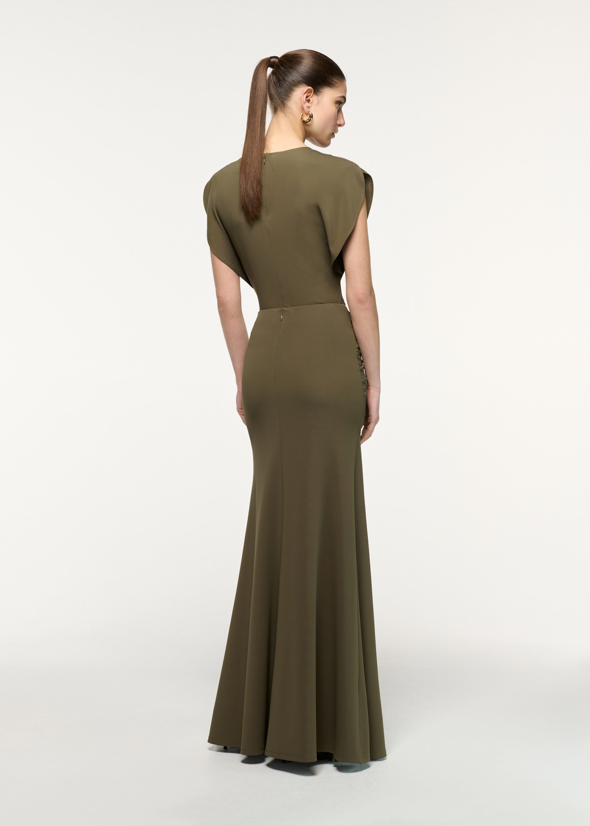 Back view of a model wearing the Waterfall Twist Drape Jersey Skirt in Khaki