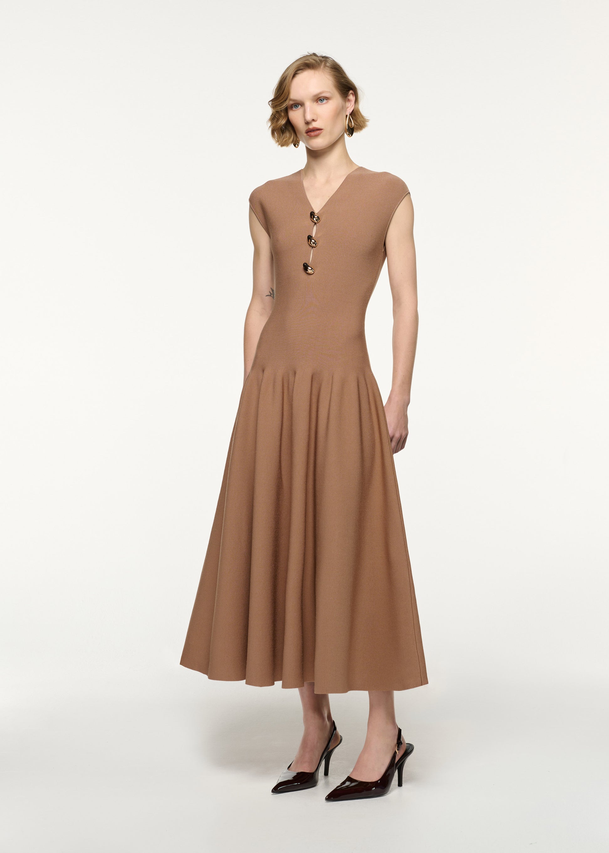 Side view of a model wearing the Pebble Trimmed Knit Dress in Camel