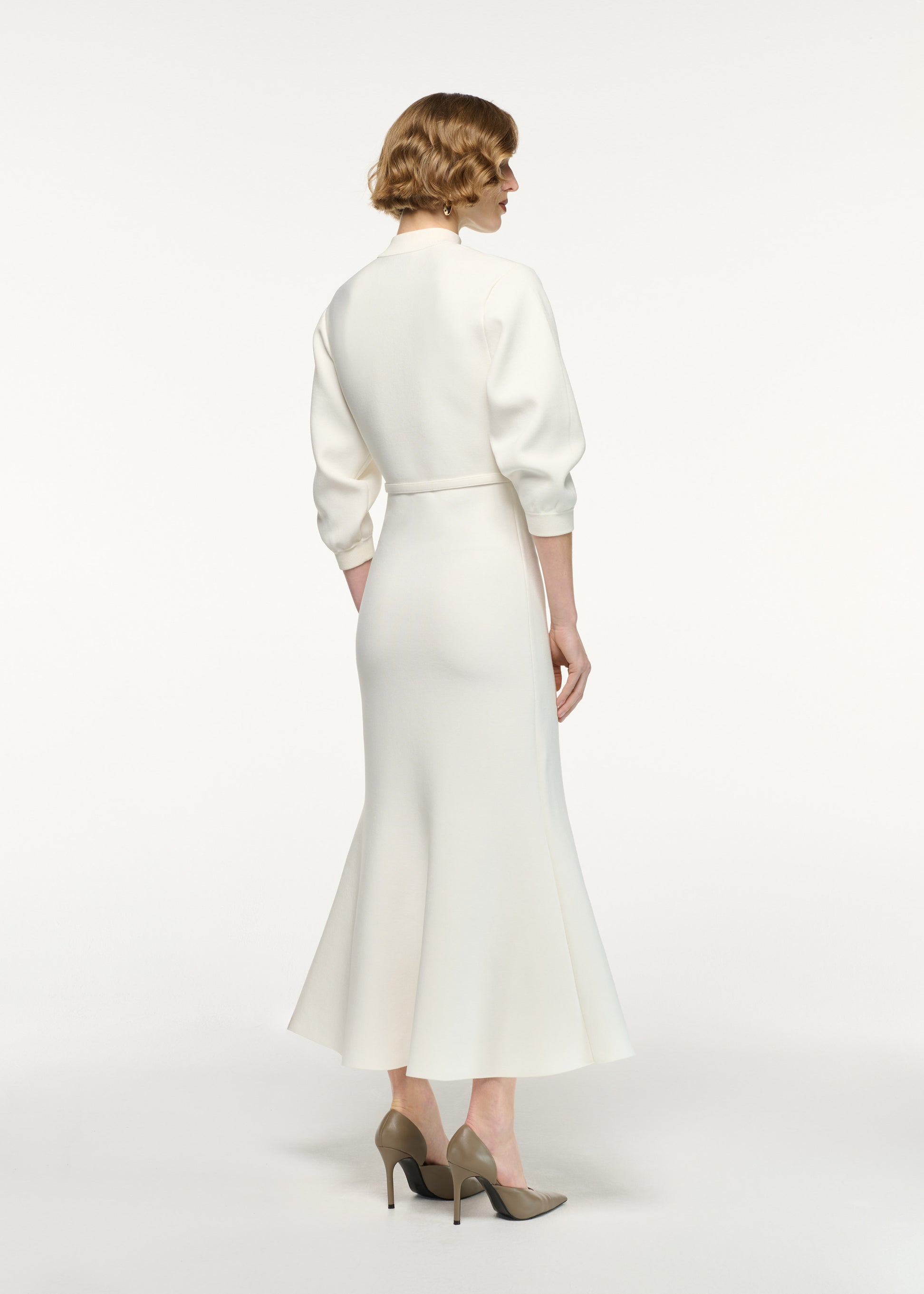 Back view of a model wearing the Belted Blouson Knit Midi Dress in Cream