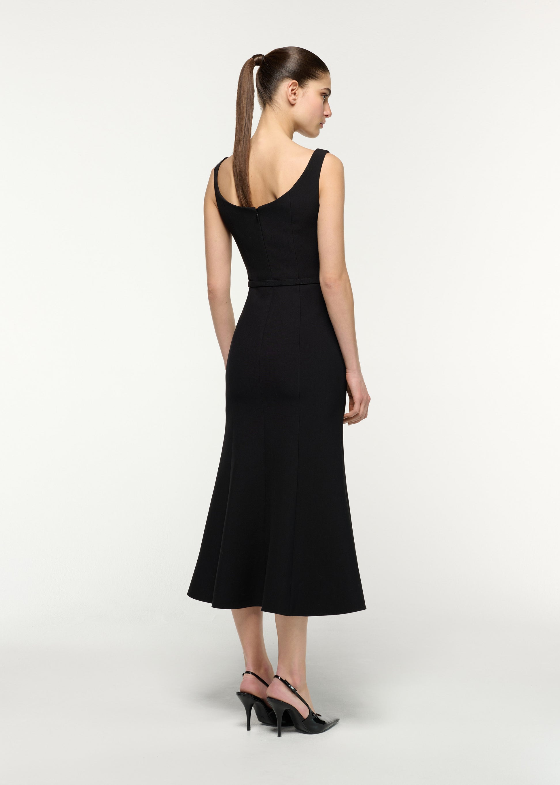 Back view of a model wearing the Belted Fit And Flare Midi Dress in Black