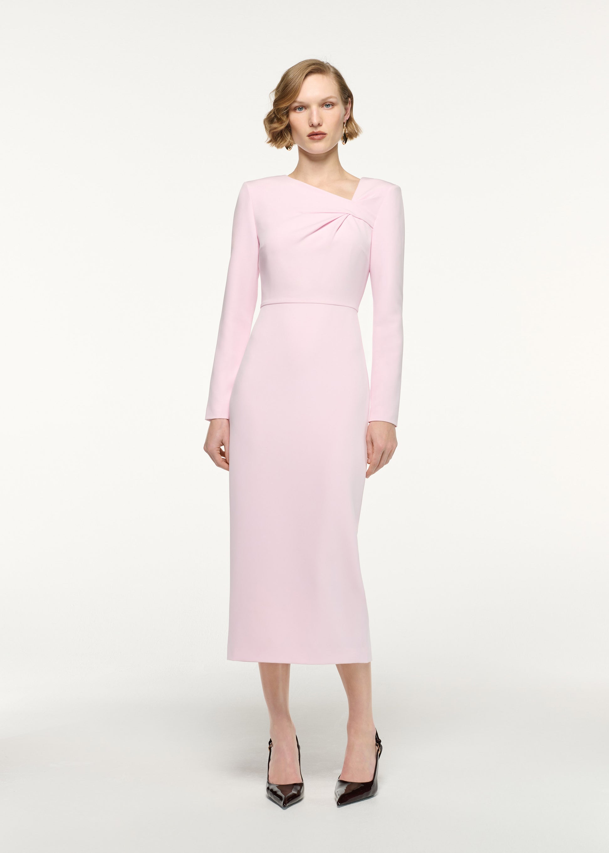 Front view of a model wearing the Asymmetric Twist Drape Midi Dress in Pink