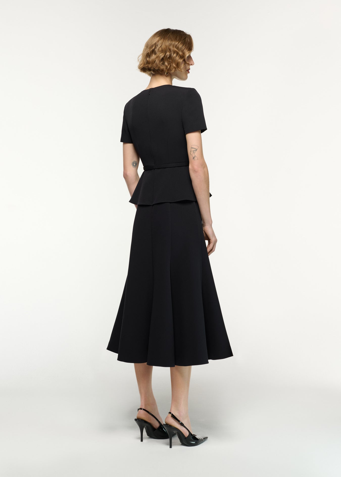 Back view of a model wearing the Flower Belted Midi Dress in Black