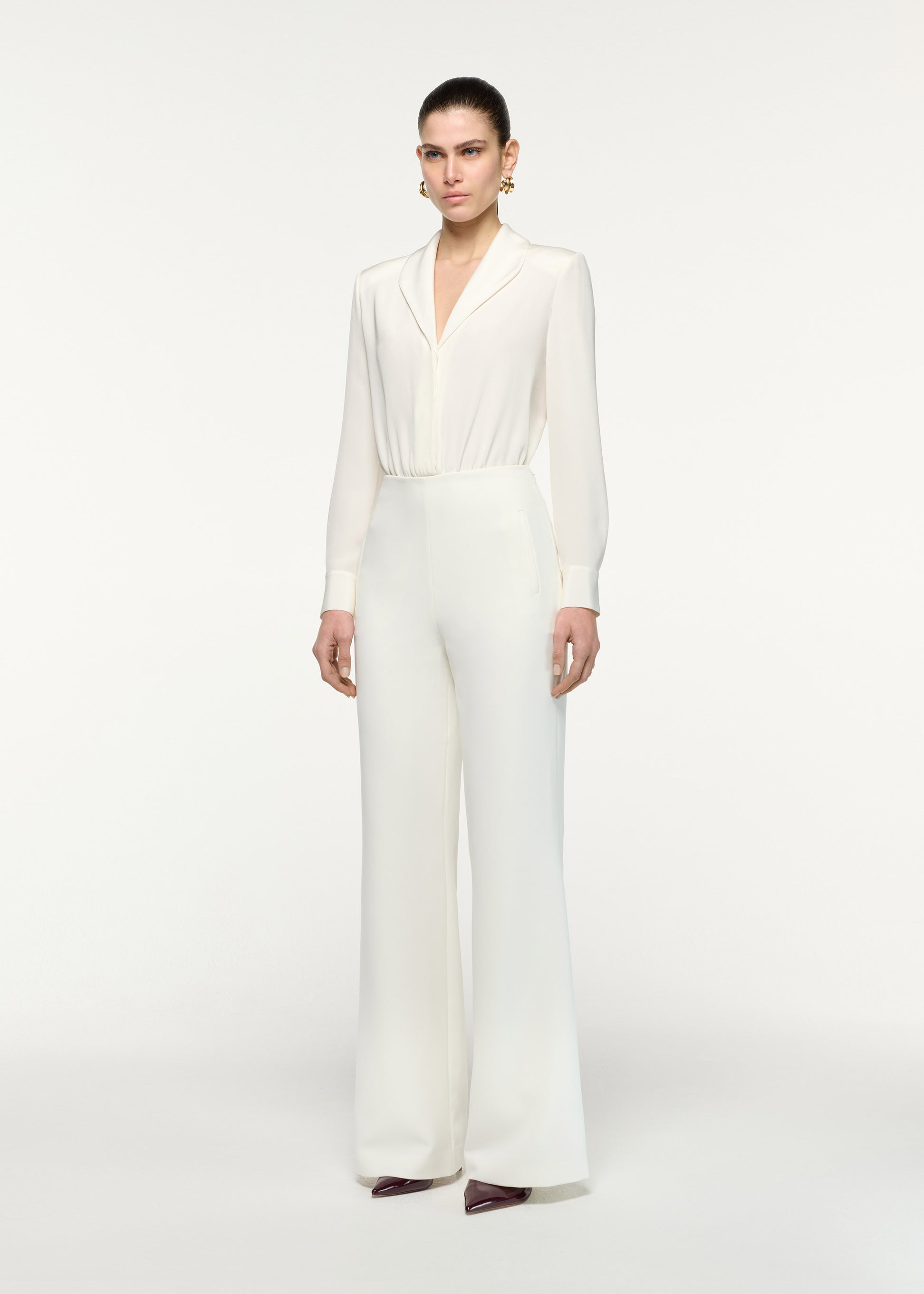 Side view of a model wearing the Silk Shirt Bodysuit in Cream