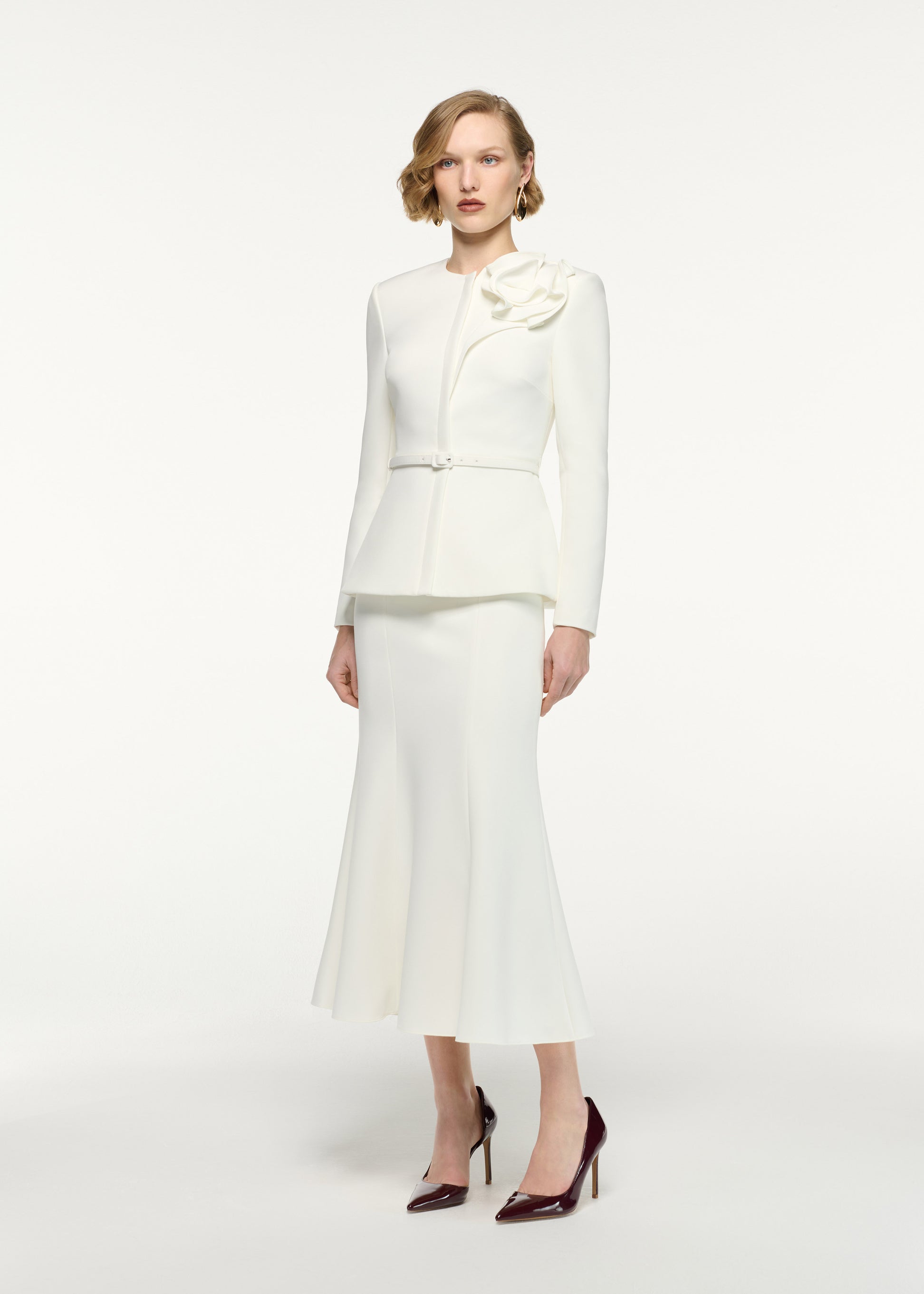 Side view of a model wearing the Fit And Flare Midi Skirt in Cream