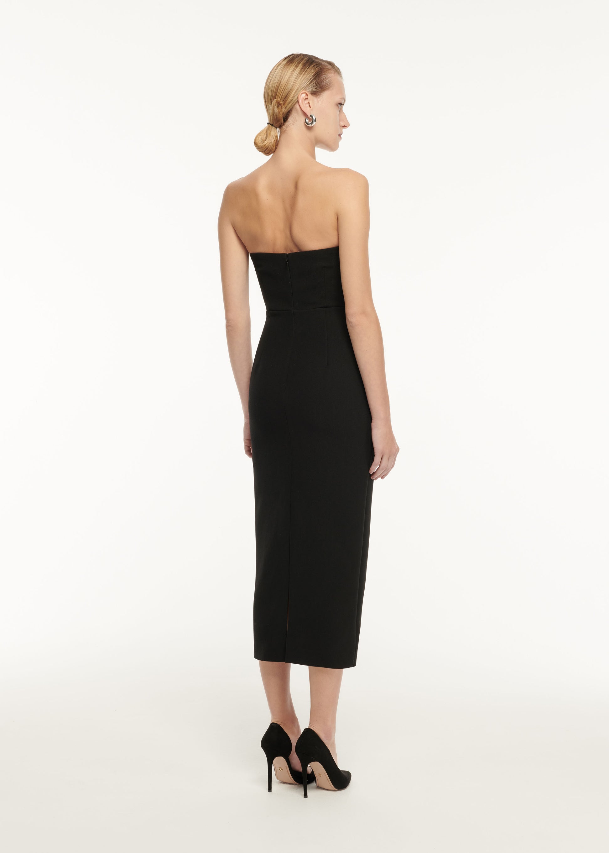 Back view of a model wearing the Strapless Drape Detail Crepe Midi Dress in Monochrome