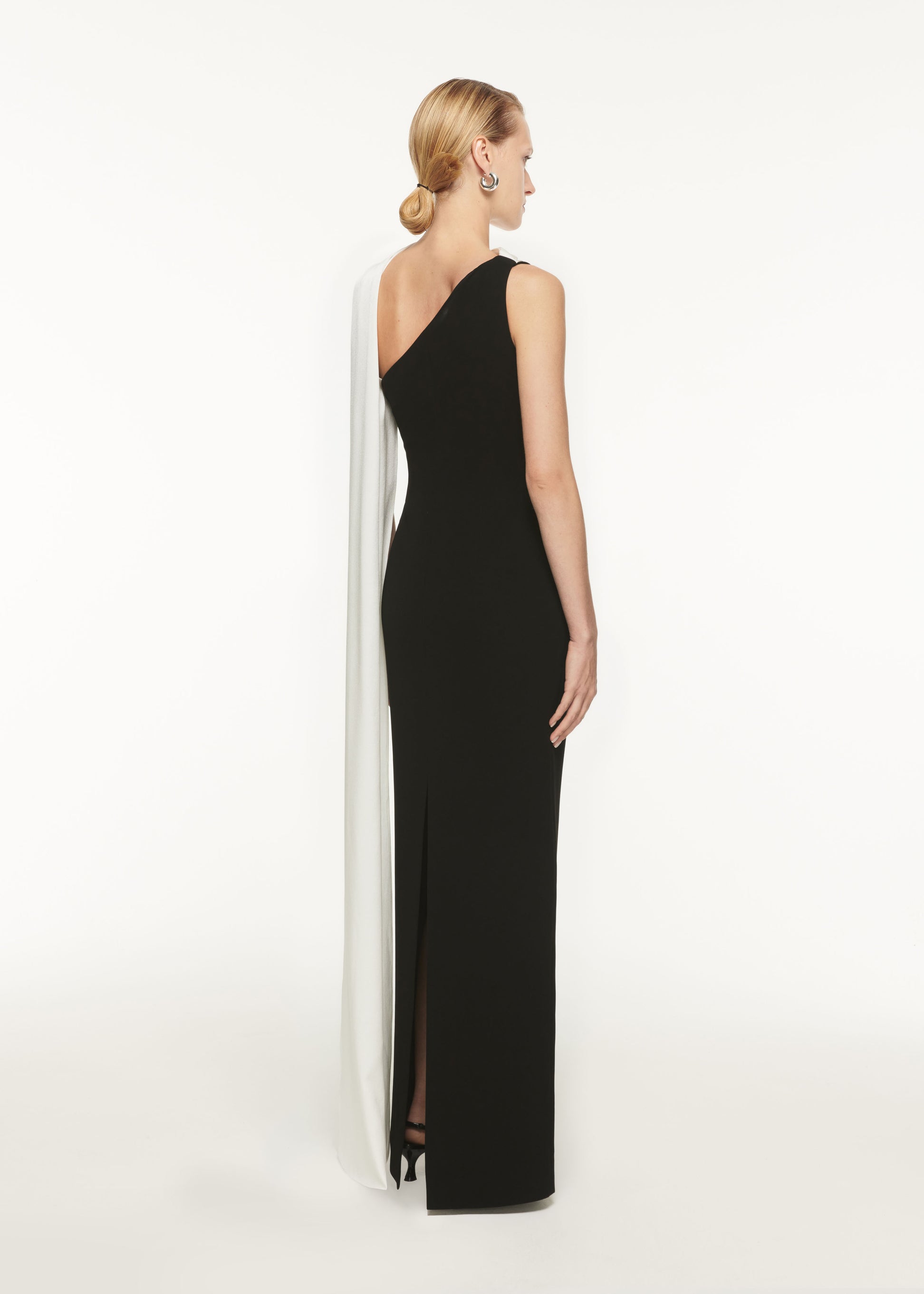 The back of a woman wearing the Asymmetric Satin Sash Maxi Dress