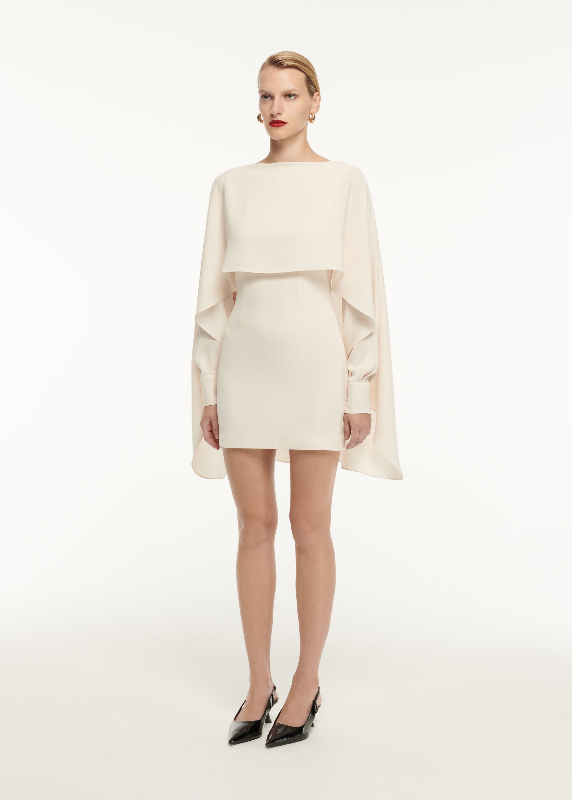 A woman wearing the Long Sleeve Satin Crepe Mini Dress in Cream